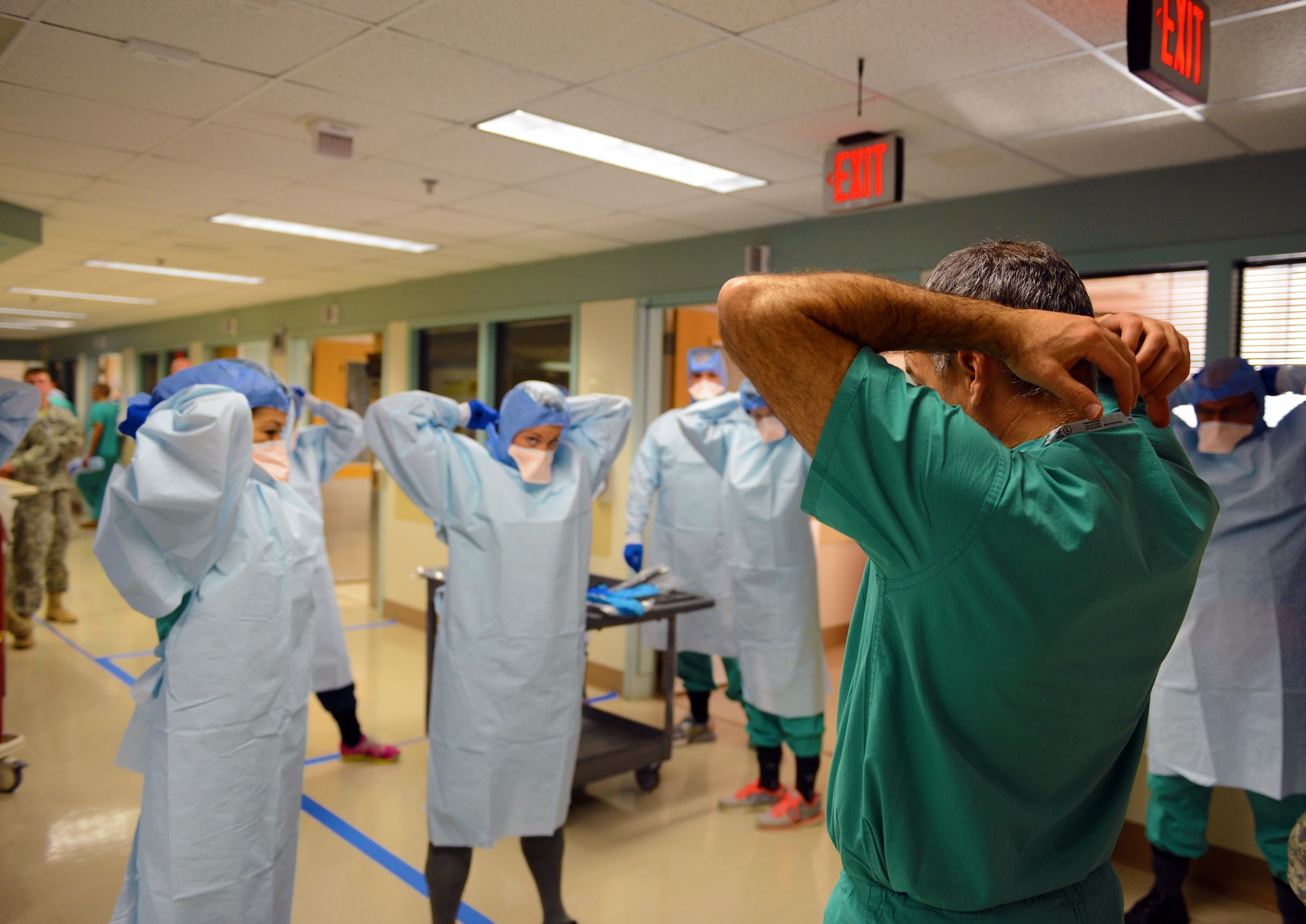 Navy Cmdr. James Lawler, right, a member of the DoD medical support team training, leads a group of students in removing their personal protective equipment during training at the San Antonio Military Medical Center in San Antonio, Texas, Oct. 24, 2014. The students are part of a 30-person team designated for “prepare to deploy” status in the event of an Ebola crisis in the U.S. (DoD photo/Army Sgt. 1st Class Tyrone C. Marshall Jr.) 