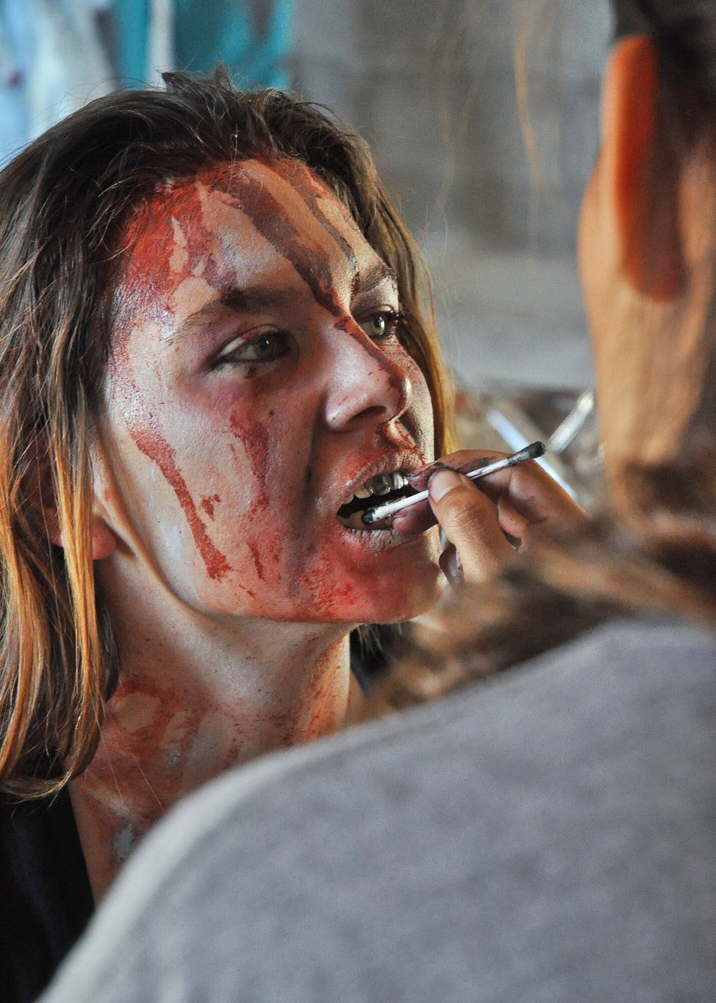A zombie gets her teeth dirtied up prior to the annual Zombie Stomp event Oct. 25 at Eglin Air Force Base, Fla.  More than 100 people attempted to outrun zombies and maneuver through various obstacles along the four-mile course. (U.S. Air Force photo/Ilka Cole)