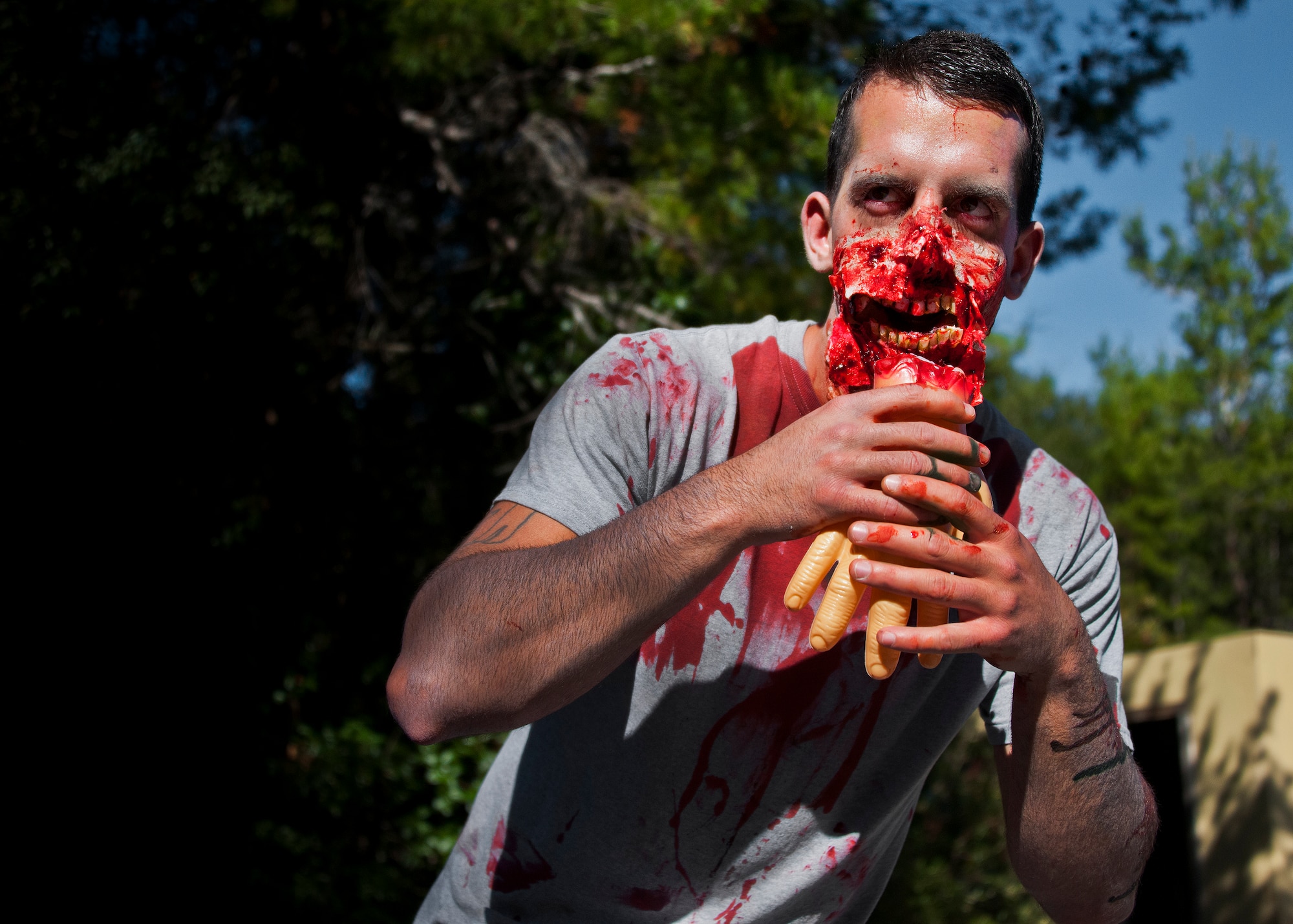 A zombie enjoys a snack while waiting for “fresh” runners during the annual Zombie Stomp event Oct. 25 at Eglin Air Force Base, Fla.  More than 100 people attempted to outrun zombies and maneuver through various obstacles along the four-mile course. (U.S. Air Force photo/Samuel King Jr.)