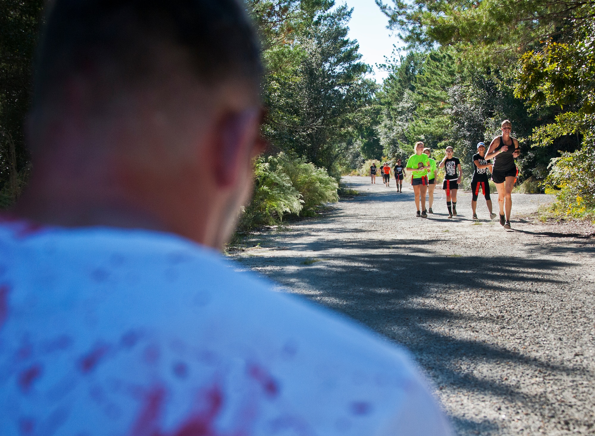 Runners approach a nest of waiting zombies during the annual Zombie Stomp event Oct. 25 at Eglin Air Force Base, Fla.  More than 100 people attempted to outrun zombies and maneuver through various obstacles along the four-mile course. (U.S. Air Force photo/Samuel King Jr.)