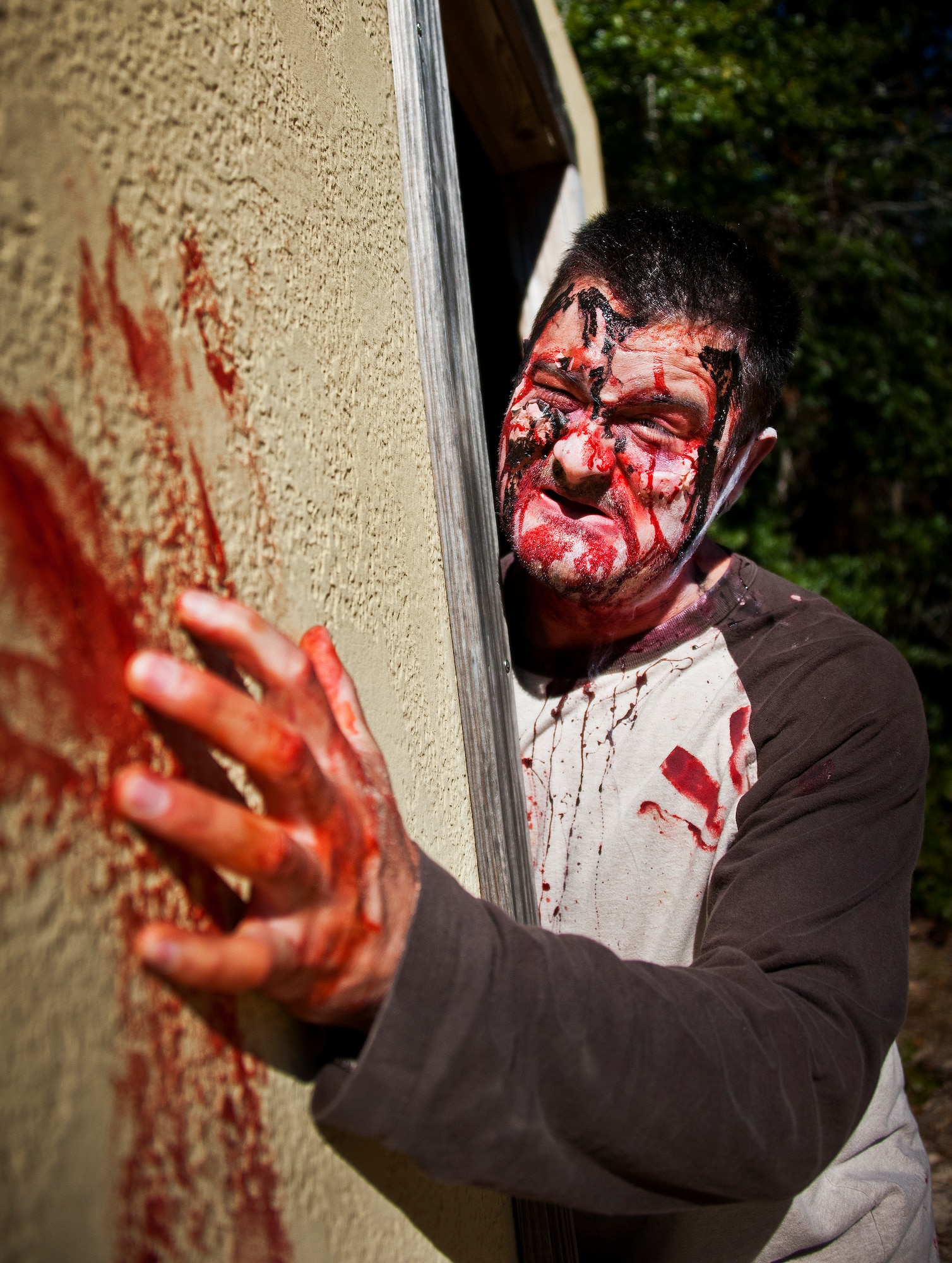 A zombie peeks around a corner looking for runners during the annual Zombie Stomp event Oct. 25 at Eglin Air Force Base, Fla.  More than 100 people attempted to outrun zombies and maneuver through various obstacles along the four-mile course. (U.S. Air Force photo/Samuel King Jr.)