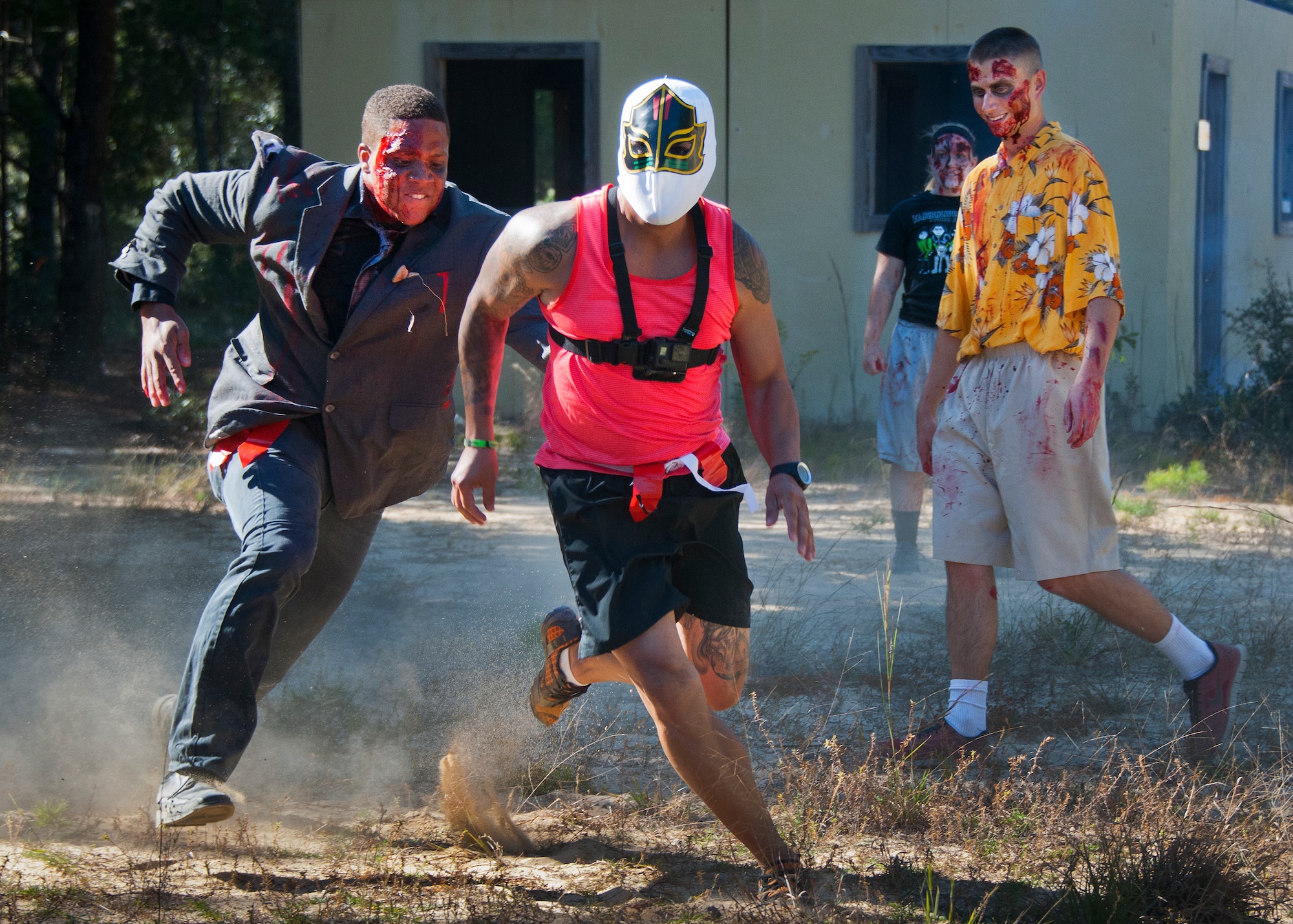 Zombies chase down a Luchador during the annual Zombie Stomp event Oct. 25 at Eglin Air Force Base, Fla.  More than 100 people attempted to outrun zombies and maneuver through various obstacles along the four-mile course. (U.S. Air Force photo/Samuel King Jr.)