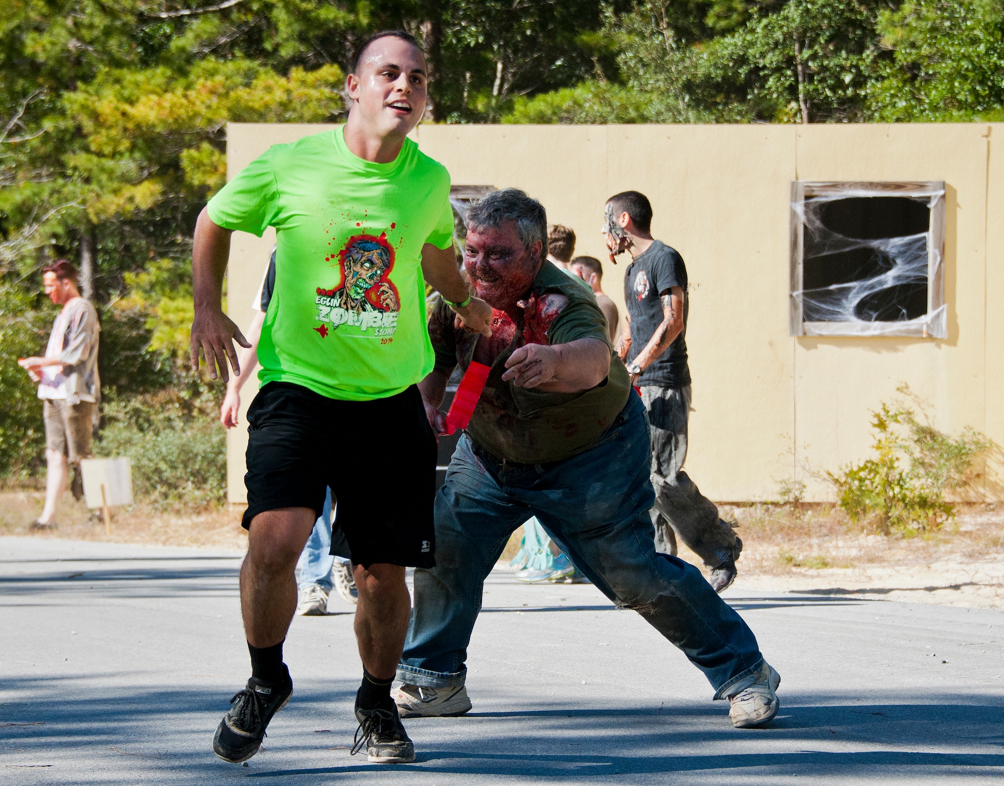 A zombie reaches out for a runner during the annual Zombie Stomp event Oct. 25 at Eglin Air Force Base, Fla.  More than 100 people attempted to outrun zombies and maneuver through various obstacles along the four-mile course. (U.S. Air Force photo/Samuel King Jr.)