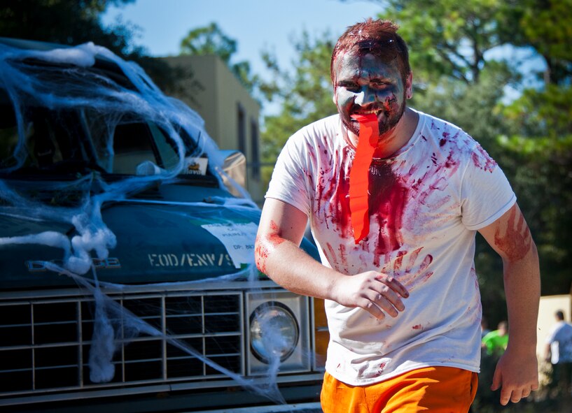 A zombie feasts on a “flesh” flag after taking a “bite” out of a runner during the annual Zombie Stomp event Oct. 25 at Eglin Air Force Base, Fla.  More than 100 people attempted to outrun zombies and maneuver through various obstacles along the four-mile course. (U.S. Air Force photo/Samuel King Jr.)