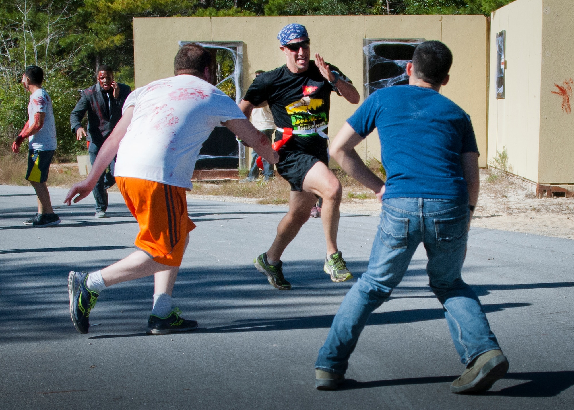 Zombies chase down a runner during the annual Zombie Stomp event Oct. 25 at Eglin Air Force Base, Fla.  More than 100 people attempted to outrun zombies and maneuver through various obstacles along the four-mile course. (U.S. Air Force photo/Samuel King Jr.)