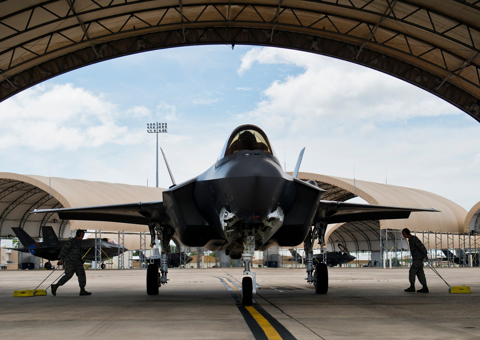 Airman 1st Class Jake Wiedmeyer and Tech. Sgt. James McCallen, 33rd Aircraft Maintenance Squadron, drag in the wheel chocks to keep the F-35A Lightning II from rolling after returning from a sortie at Eglin Air Force Base, Fla.  (U.S. Air Force photo/Samuel King Jr.)