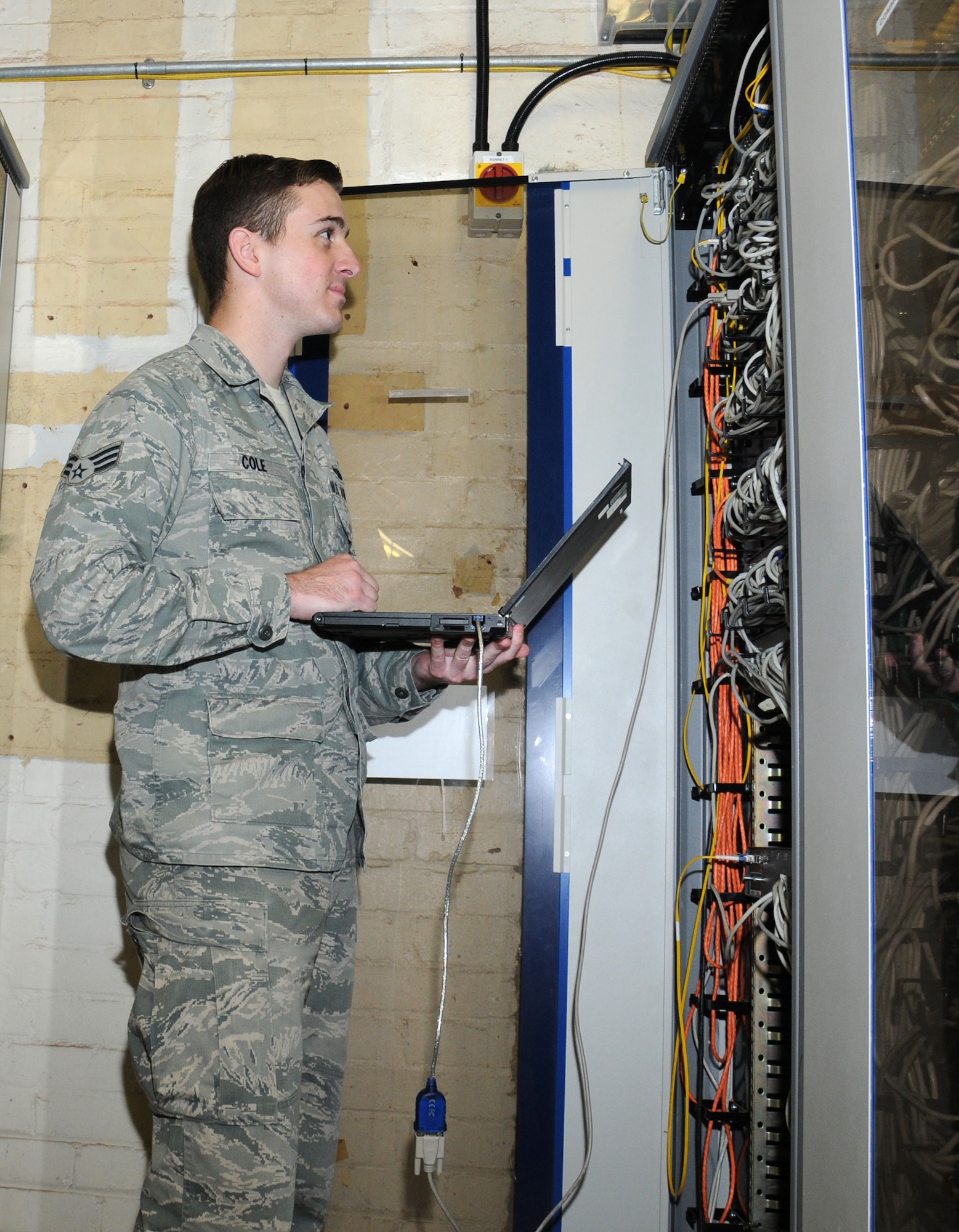 U.S. Air Force Senior Airman Christopher Cole, 100th Communication Squadron cyber transport technician from Merced, Calif., programs switches Sept. 17, 2014, on RAF Mildenhall, England. Cole can program ports using a network cable to a switch so computers and phones can communicate on the network. (U.S. Air Force photo by Gina Randall/Released)