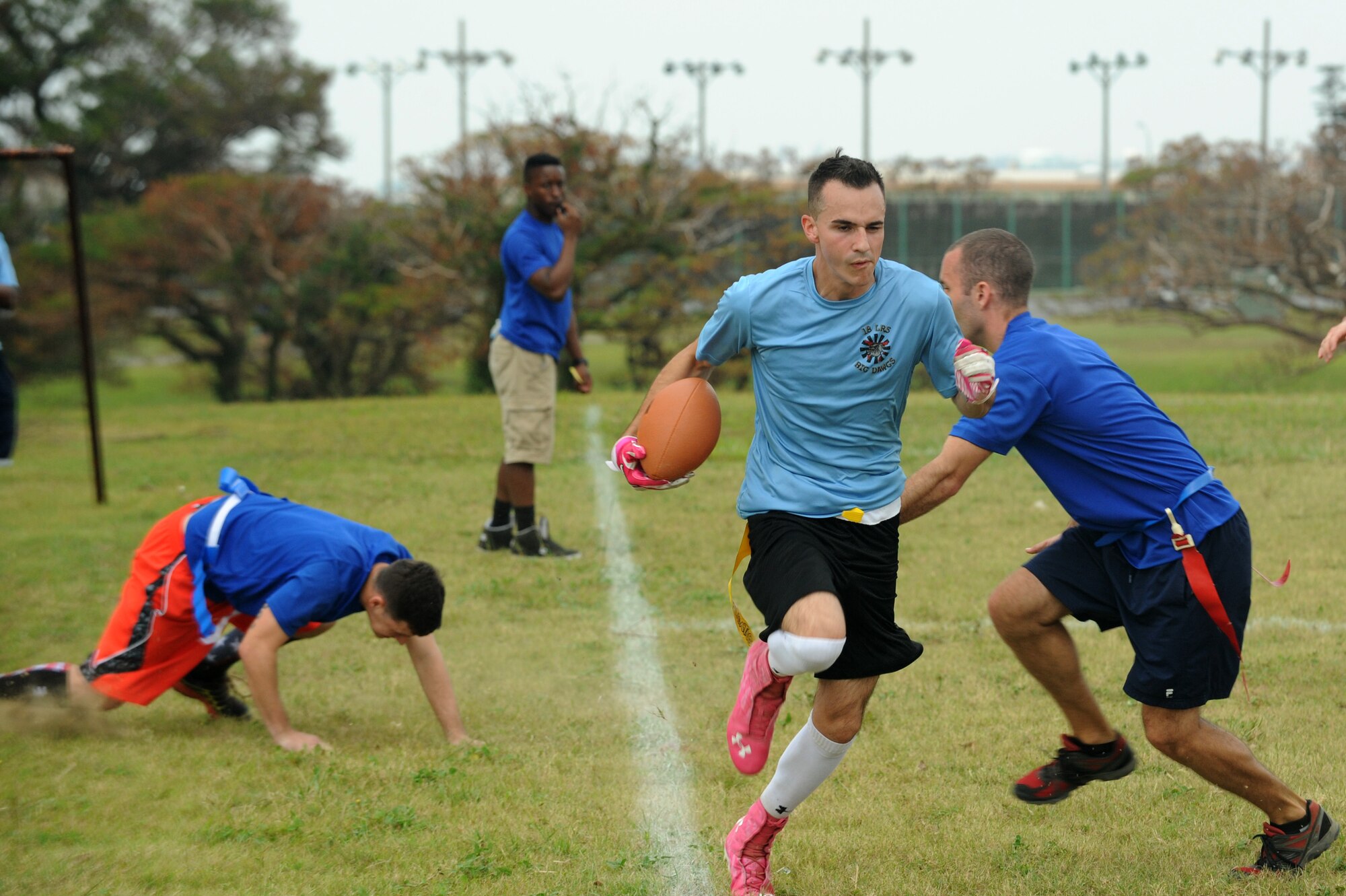 An Airman from the 18th Logistics Readiness Squadron runs down the sideline during a flag football game on Kadena Air Base, Japan, Oct. 24, 2014. The game was part of the 18th Mission Support Group sports day. The sports day is intended for all of the squadrons in the group to compete and boost morale in a day full of competition. (U.S. Air Force Photo by Airmen 1st Class Stephen G. Eigel/Released)