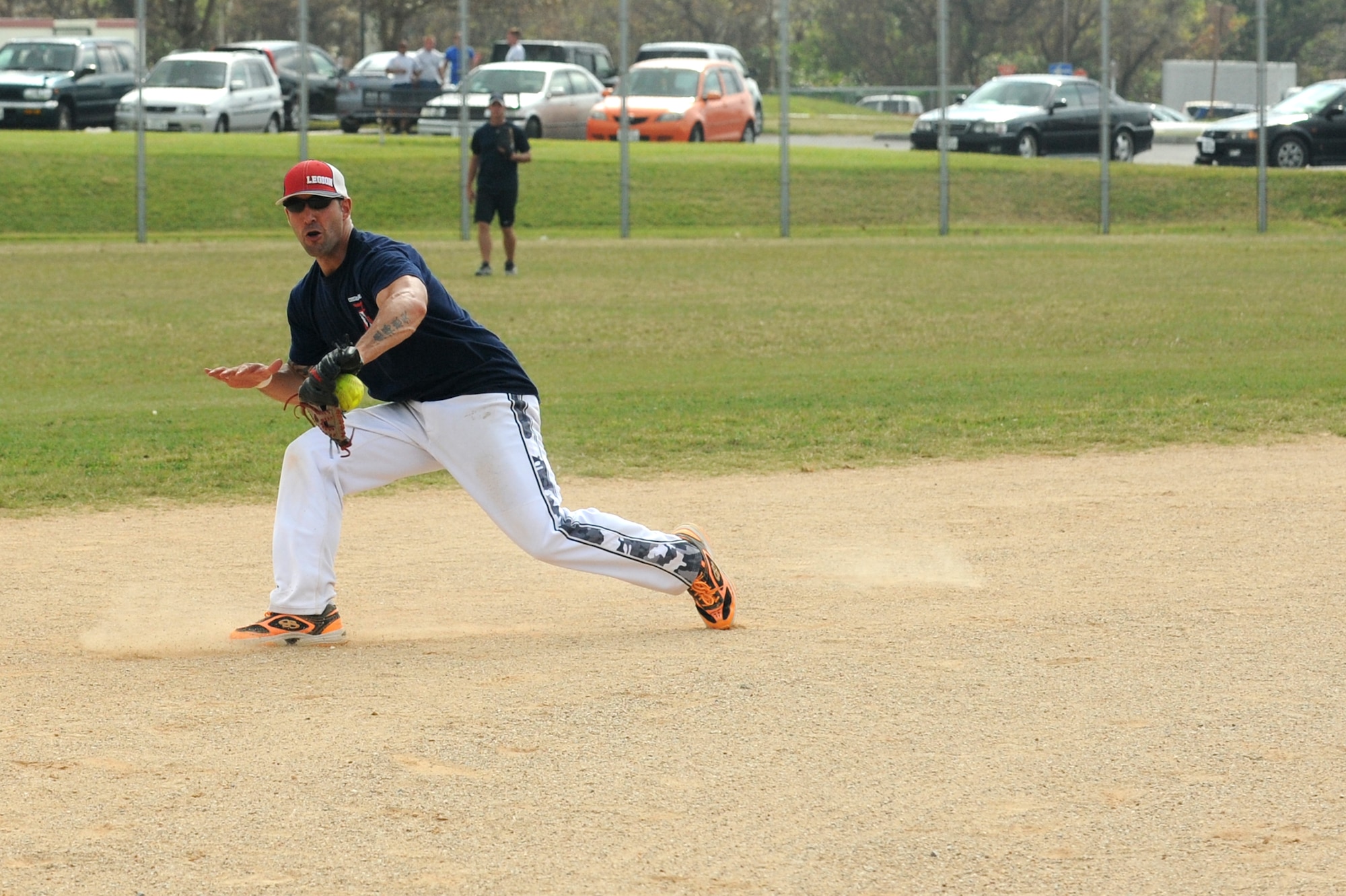 U.S. Air Force Master Sgt. Brandon Wolfgang, 18th Security Forces Squadron superintendent of flight operations, stops a ball at shortstop during a softball game on Kadena Air Base, Japan, Oct. 24, 2014. The game was part of the 18th Mission Support Group sports day. The sports day is intended for all of the squadrons in MSG to compete and boost morale in a day full of competition. (U.S. Air Force Photo by Airmen 1st Class Stephen G. Eigel/Released)