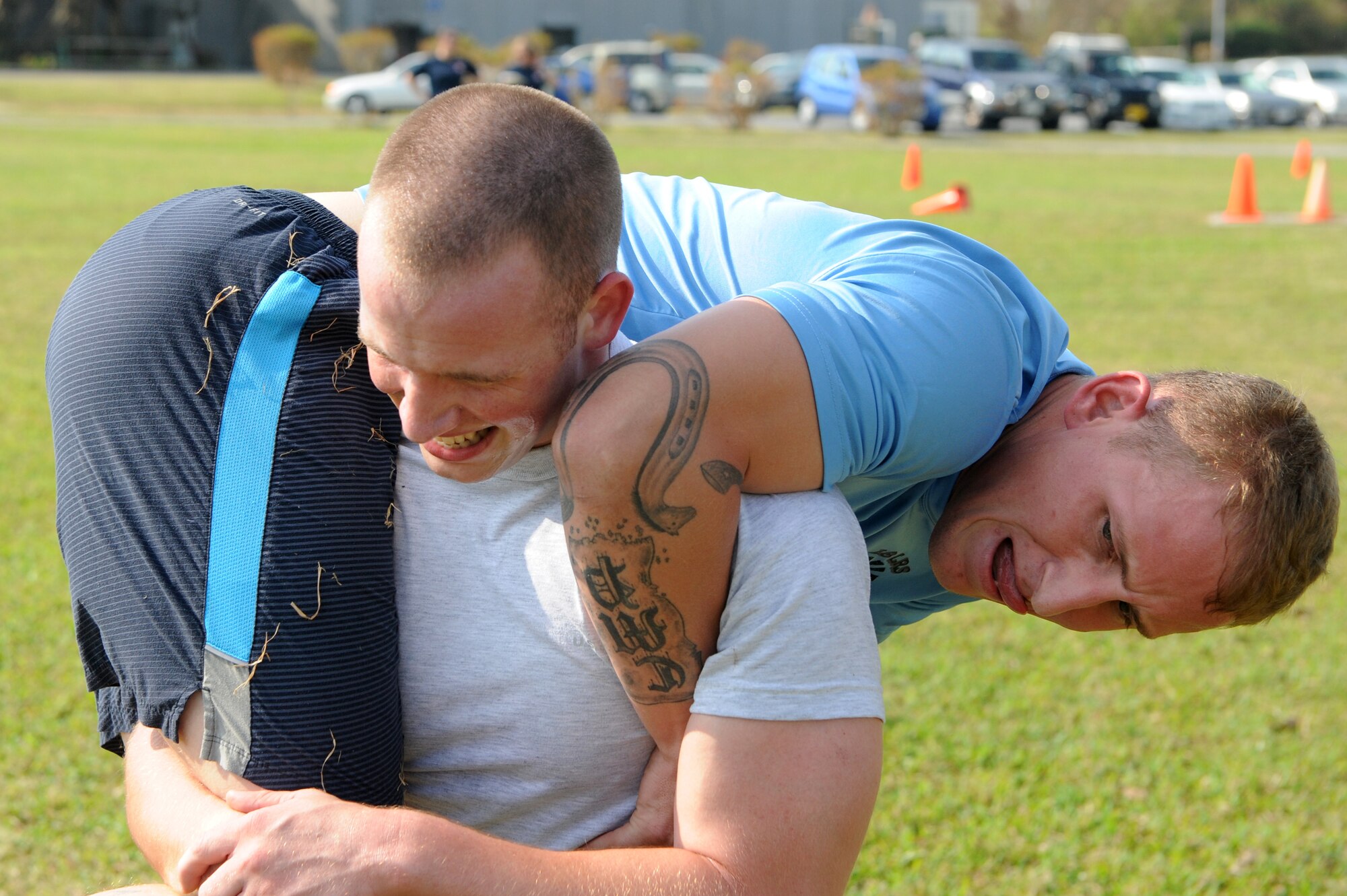 Airmen from the 18th Logistics Readiness Squadron perform buddy carries during the Defenders Challenge on Kadena Air Base, Japan, Oct. 24, 2014. The Defenders Challenge was one of many events in the annual 18th Mission Support Group sports day. (U.S. Air Force Photo by Airmen 1st Class Stephen G. Eigel/Released)