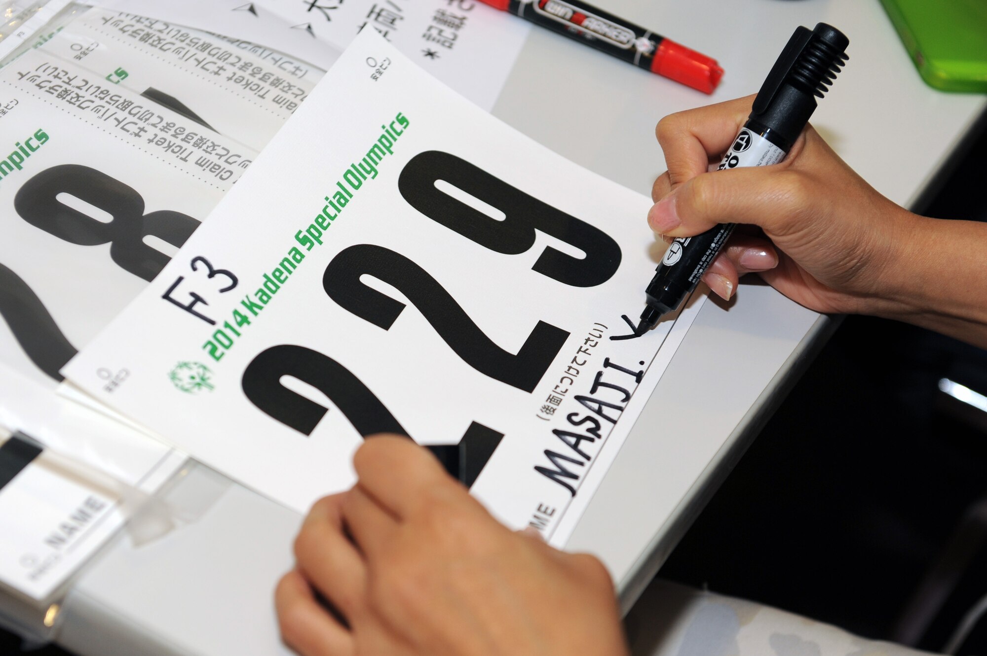 A volunteer prepares a sports bib for a Kadena Special Olympics athlete on Kadena Air Base, Japan, Oct. 23, 2014. More than 100 volunteers gathered at the Schilling Community Center to prepare the packages for the athletes in preparation for KSO Game Day, which is scheduled to take place Nov. 8 at the Risner Fitness Complex. (U.S. Air Force photo by Airman 1st Class Zade C. Vadnais/Released)