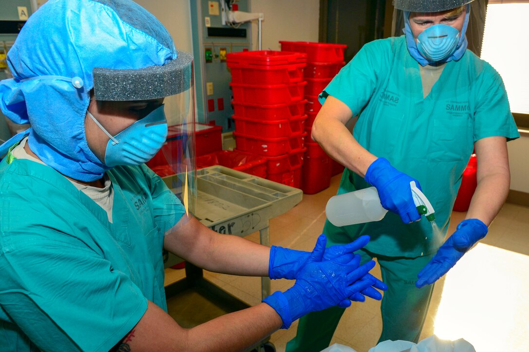 Maj. Virginia Vardon-Smith, right, sprays disinfectant on her gloves before removing them during training at San Antonio Military Medical Center, Texas, Oct. 23, 2014. A 30-person team is being trained to respond quickly, effectively and safely in the event of additional Ebola cases in the United States. Vardon-Smith is a nurse specialist assigned to the Dwight D. Eisenhower Army Medical Center Clinical Intensive Care Unit.