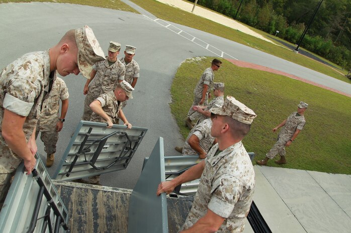 U.S. Marines offload tables intended for use during vaccination during Exercise Vigilant Response 2014 (VR14) aboard Marine Corps Air Station New River, N.C., Oct. 7, 2014.  VR14 is a two-day exercise designed to test the ability to conduct command and control measures in response to a pandemic outbreak aboard the Air Station.