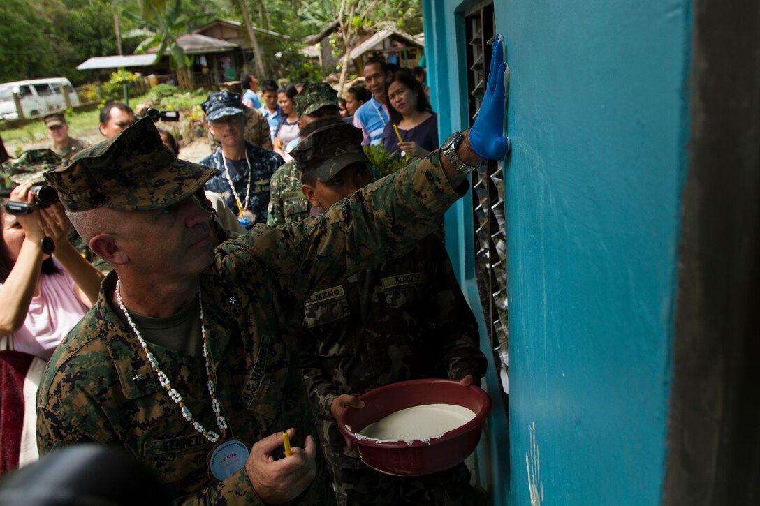 U.S. Marine Corps Brig. Gen. Paul Kennedy, commanding general, 3rd Marine Expeditionary Brigade, puts his hand print on the wall of the new class room during the engineering civic action project hand-over and dedication ceremony part of Amphibious Landing Exercise (PHIBLEX) 15 in Palawan,
Philippines, October 8, 2014. PHIBLEX is an annual, bilateral training exercise conducted by the Armed Forces of the Philippines, U.S. Marines and Navy to strengthen interoperability across a range of capabilities to include disaster relief and contingency operations. (U.S. Marine Corps photo by Lance Cpl. Andrew Blanco/RELEASED)
