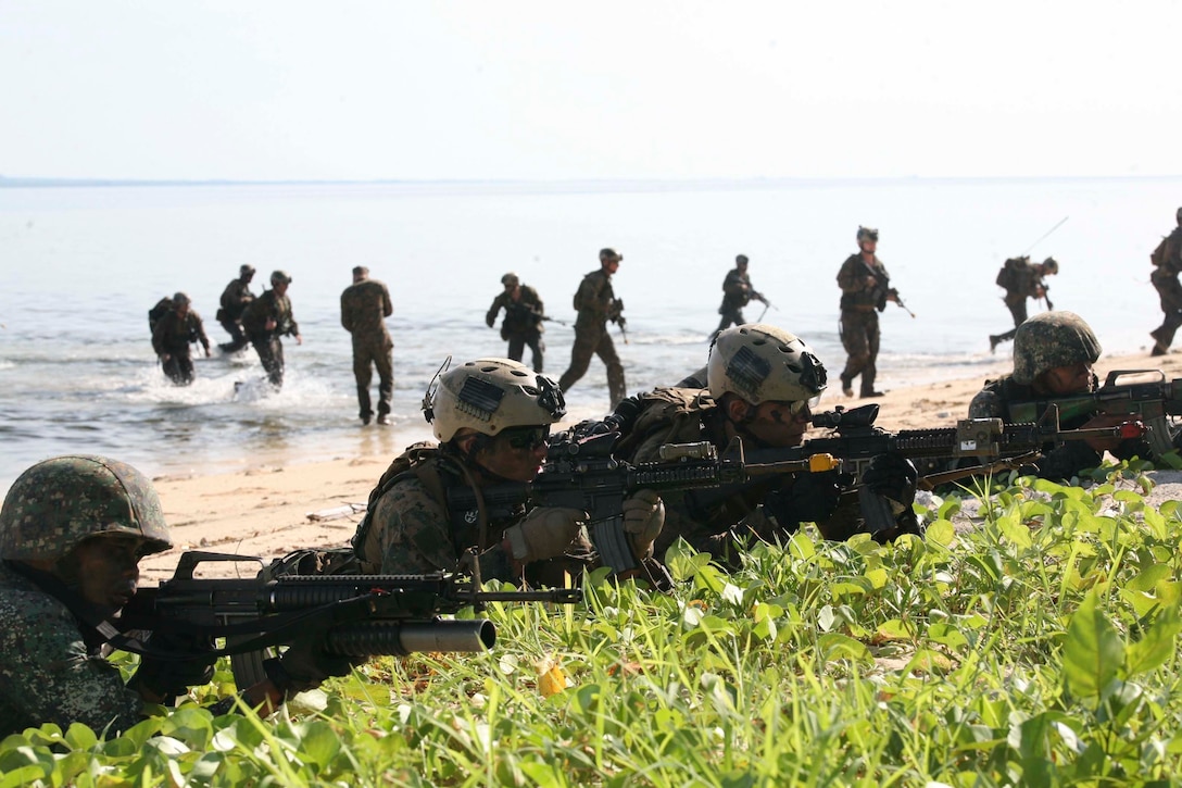 Philippine and U.S. Marines provide security while simulating a raid on a small island off the coast of Palawan, Philippines, Oct. 2 during Amphibious Landing Exercise 2015. The amphibious assault and boat raids were conducted by U.S. Marines to complete a certification exercise being held in conjunction with PHIBLEX 15. PHIBLEX is an annual, bilateral training exercise conducted by the Armed Forces of the Philippines, U.S. Marines and Navy to strengthen interoperability across a range of capabilities, including disaster relief and contingency operations. The AFP Marines are with 12th Marine Battalion, Philippine Marine Corps, and the U.S. Marines are with Battalion Landing Team 3rd Battalion, 5th Marine Regiment, 31st Marine Expeditionary Unit. (U.S. Marine Corps photo by Sgt. Anthony J. Kirby/Released)