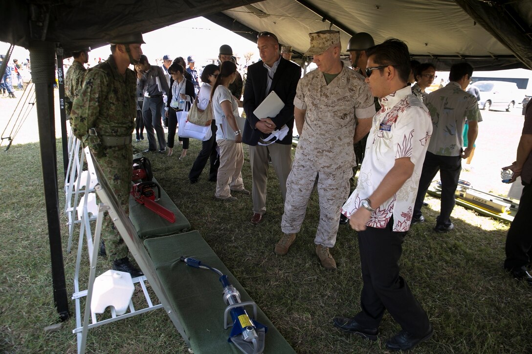 Tetsuji Matsumoto, right, Maj. Gen. Charles L. Hudson, left of Matsumoto, and Dr. Robert D. Eldridge, left of Hudson, view tools and equipment at the Japan Ground Self-Defense Force 15th Brigade static display Oct. 28 during Exercise Constant Vigilance 2014 here. The exercise, which included personnel assigned to the Japan Self-Defense Force, Marine Corps Installations Pacific-Marine Corps Base, Camp Butler Japan, Urasoe City, Camp Kinser emergency services, Department of Defense Dependents Schools, and other civilian agencies, simulated a collaborative emergency response to a tsunami and tested cooperative emergency response procedures. Matsumoto is the mayor of Urasoe City. Hudson is the commanding general of MCIPAC-Marine Corp Base, Camp Butler Japan. Eldridge is the deputy assistant chief of staff for G-7, government and external affairs, MCIPAC-Marine Corps Base, Camp Butler Japan.