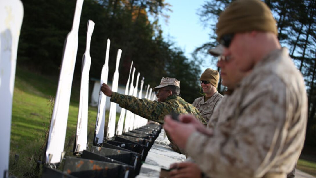 Lance Cpls. James Leiter and Christopher Robeson score and repair a target during the combat pistol program pre-qualification at the Combat Marksmanship Coaches Course at the Marksmanship Training Unit, Weapons Training Battalion in Quantico, Va., Oct. 24, 2014. This particular CMC course was staffed entirely by Reserve Marines from the Marine Corps Reserve Shooting Team, who are the top competitive shooters in the Marine Corps Reserve.