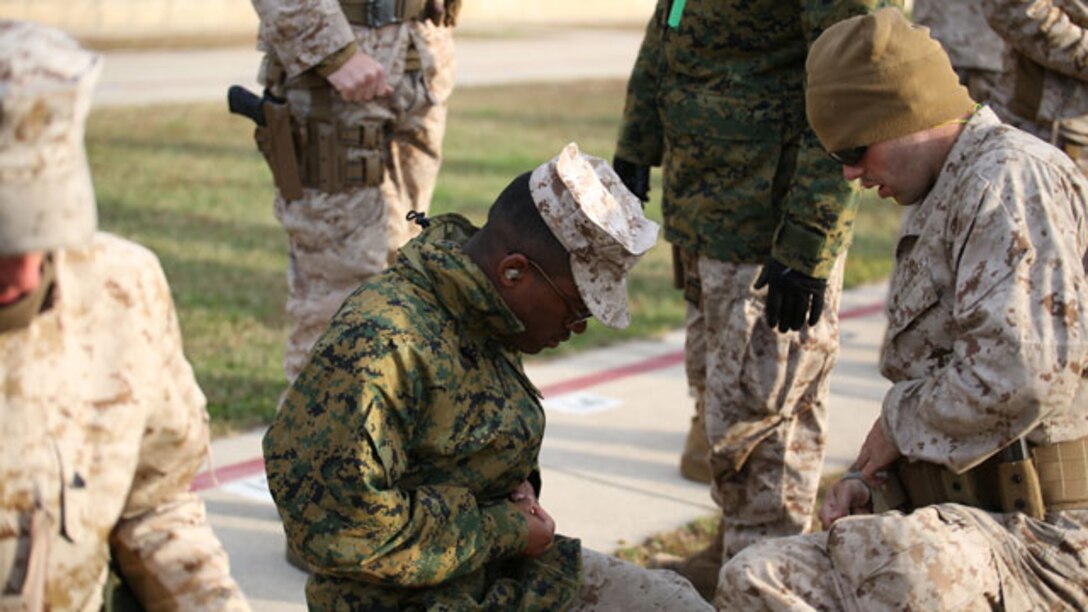 Lance Cpl. James Leiter (right) helps fellow marksmanship student Lance Cpl. Christopher Robeson (left) load magazines for the next round of fire during the combat pistol program qualification at the Combat Marksmanship Coaches Course at the Marksmanship Training Unit, Weapons Training Battalion in Quantico, Va., Oct. 24, 2014. This particular CMC course was staffed entirely by Reserve Marines from the Marine Corps Reserve Shooting Team, who are the top competitive shooters in the Marine Corps Reserve.