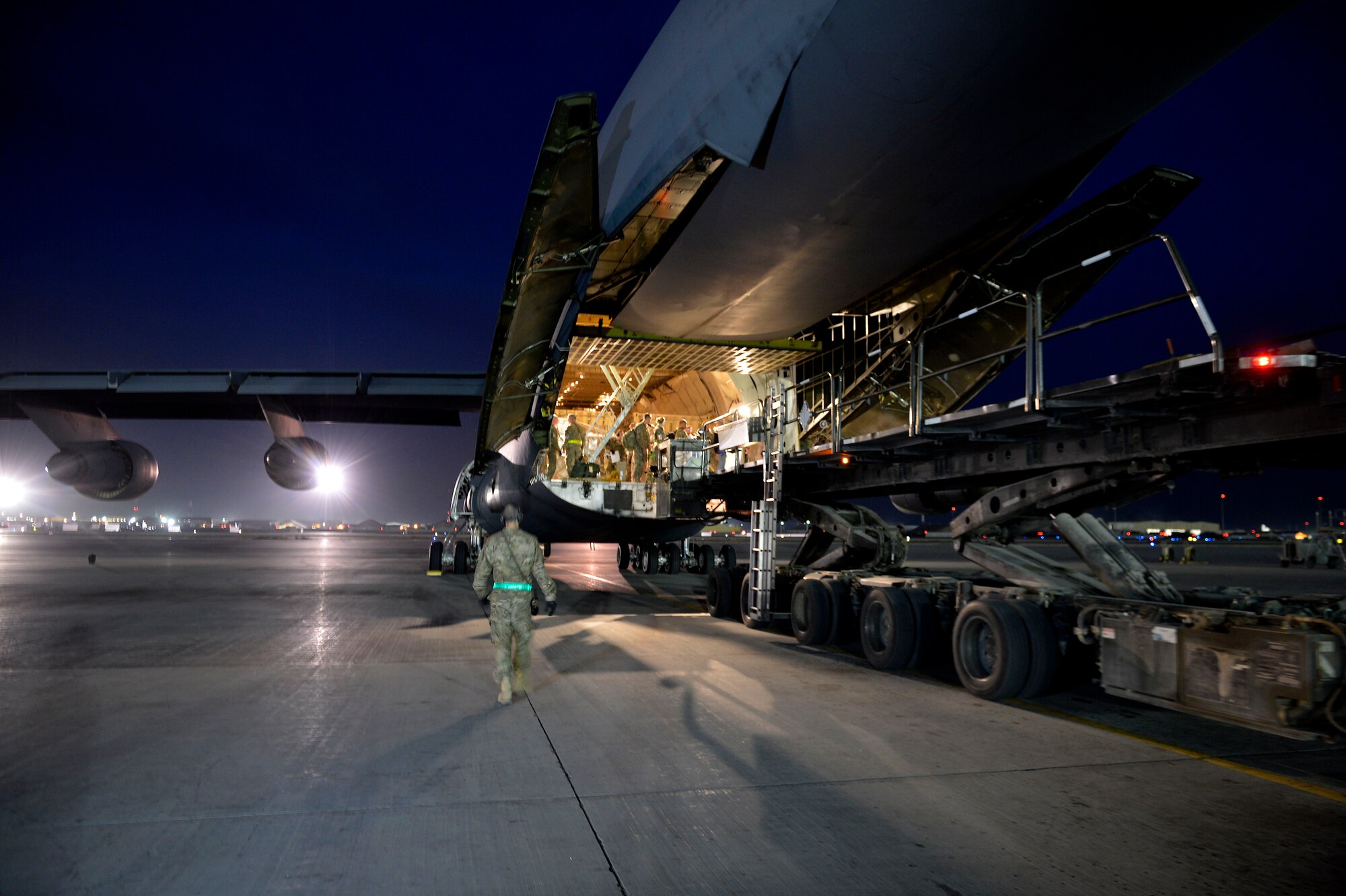 U.S. Air Force Airmen with the 455th Expeditionary Aerial Port Squadron load cargo into a C-17 Globemaster III loadmaster Sept. 9, 2014. Airmen assigned to the 455 EAPS have serviced more than 14,300 missions and 114,700 short tons of cargo since the beginning of the year to support Operation Enduring Freedom. (U.S. Air Force photo by Staff Sgt. Evelyn Chavez/Released)