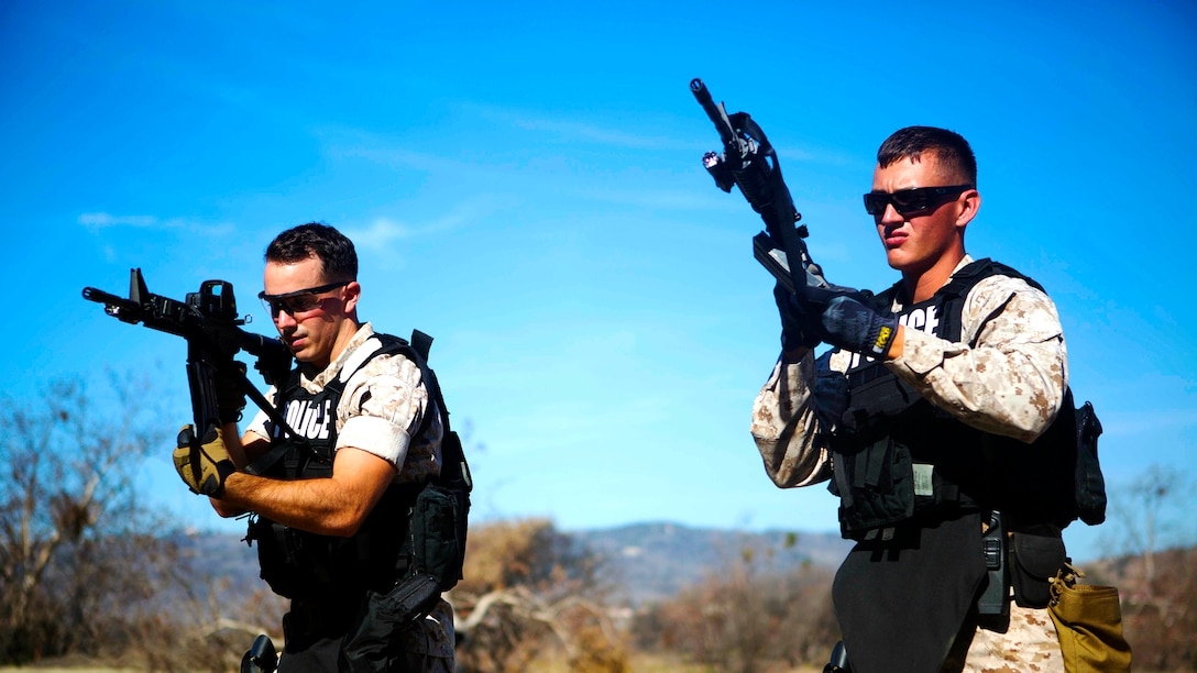 Lance Cpl. Kevin Dooling and Lance Cpl. Justin Mullen, members of the Provost Marshall Office Special Reaction Team, conduct tactical reloads prior to a live-fire training evolution at Range 300, Oct. 23.  The SRT is responsible for any critical situations that fall beyond the capabilities of ordinary law enforcement. 