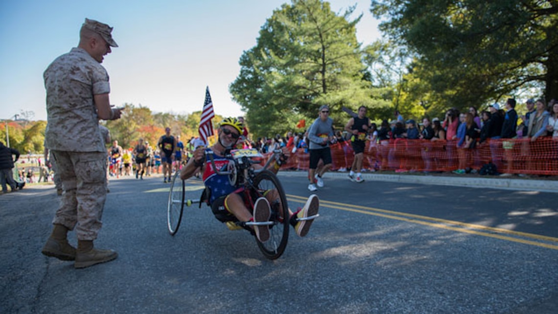A Marine motivates Paul Kelly, a native of North Carolina, as he pushes through the last stretch of the 39th Marine Corps Marathon in Arlington, Va. Twenty-six thousand, one hundred sixty-one marathon runners crossed the start line this year.
