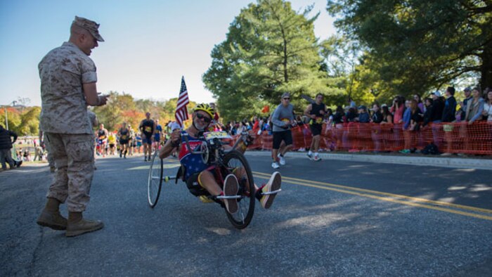A Marine motivates Paul Kelly, a native of North Carolina, as he pushes through the last stretch of the 39th Marine Corps Marathon in Arlington, Va. Twenty-six thousand, one hundred sixty-one marathon runners crossed the start line this year.
