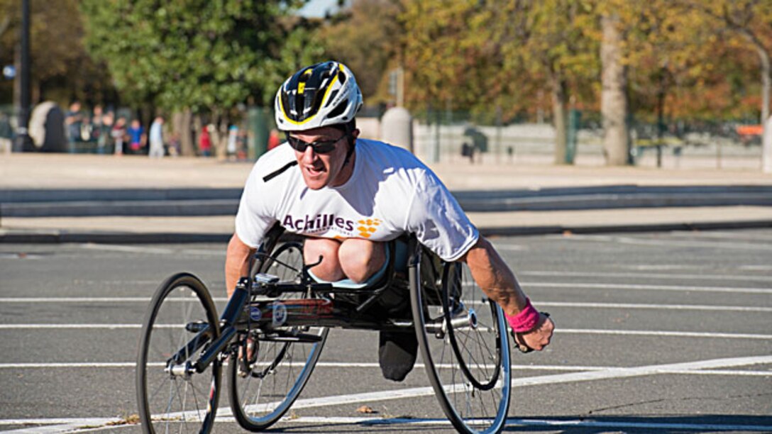 A hand cyclist pedals past the U.S. Capitol during the 2014 Marine Corps Marathon Oct. 26 in Washington, D.C. This is the Marine Corps Marathon’s 39th running year. Runners from 59 countries participated in the event with a grand total of 26,161. (U.S. Marine Corps photo by Cpl. Eric Keenan/released)