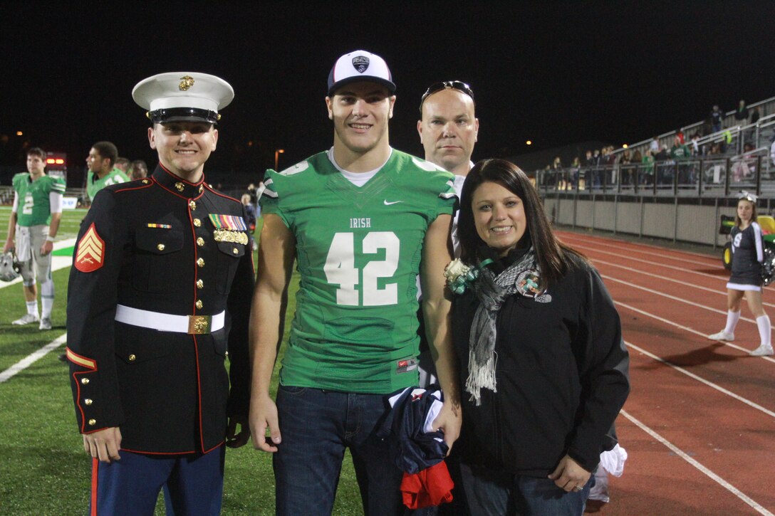 Nick Conner, a linebacker with the Dublin Scioto High School football team, poses for a photo alongside his parents, Scott and Renee, and U.S. Marine Corps Sgt. Nikolas Cimmarrusti, a Marine recruiter for the Dublin, Ohio, area. Conner has been officially selected to play in the Marine Corps Semper Fidelis All American Bowl, which will be held Jan. 4, 2015 in Carson, California. (U.S. Marine Corps photo by Sgt. Tyler Hlavac/Released)