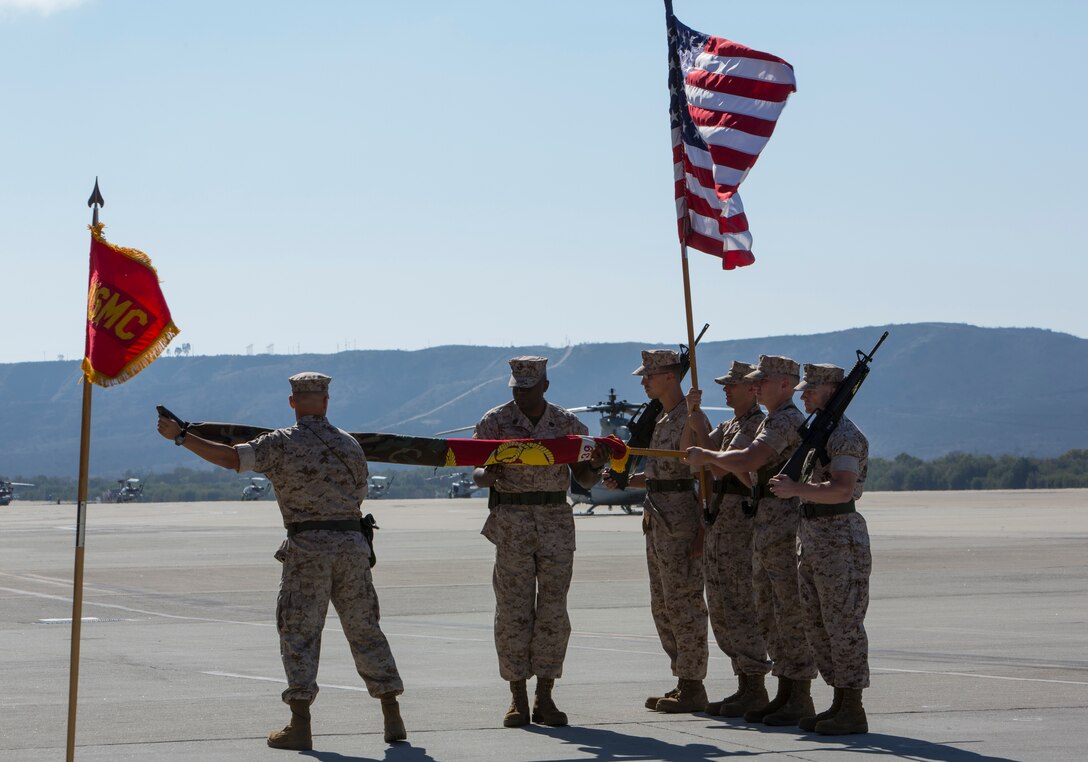 Lt. Col. Paul B. Kopacz, left, oncoming commanding officer of now Marine Medium Tiltrotor Squadron (VMM) 364, unravels the new guidon VMM-364 during a change of command and redesignation ceremony aboard Marine Corps Air Station Camp Pendleton, Calif., Oct. 9. This signified the activation of a new squadron.