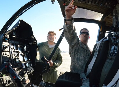 Chief Warrant Officer Sean Hogan of the Florida Army National Guard, right, points out the military features of an OH-58 Kiowa helicopter to Chief Pilot Richard Bray of the Alachua County Sheriff’s Office on Oct. 16, 2014, at Cecil Commerce Center in Jacksonville, Fla. Three of the remaining Florida National Guard Kiowas based in Jacksonville are being transferred to different Florida sheriffs’ offices to augment their aviation programs. 