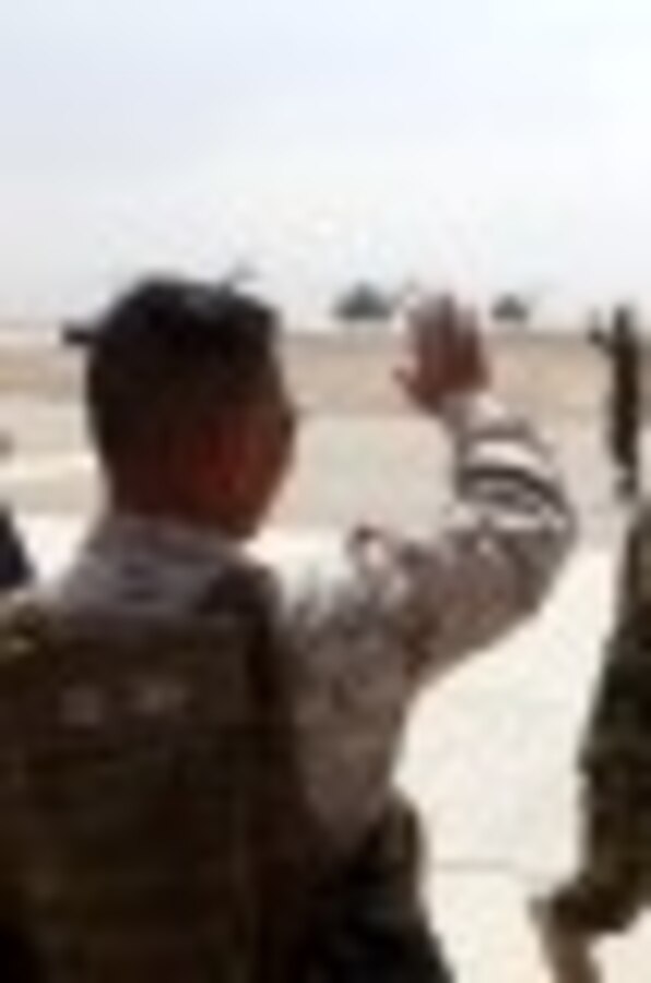 Brigadier Gen. Daniel D. Yoo, commanding general, Marine Expeditionary Brigade – Afghanistan, waves goodbye to Maj. Gen. Sayed Malouk, the Afghan National Army’s 215th Corps commander, prior to departing Helmand province, Oct. 27, 2014. The United States Marine Corps ended their operations in southwestern Afghanistan and transferred the base to the ANA.