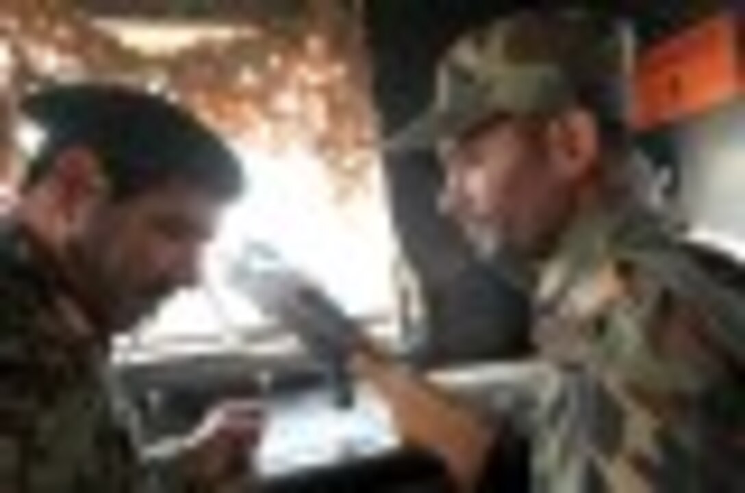 Major Gen. Sayed Malouk, the commander of the Afghan National Army’s 215th Corps, speaks with one of his soldiers as he assumes watch on a tower of the Camp Leatherneck perimeter, Oct. 27, 2014. The United States Marine Corps ended their operations in Helmand province, Afghanistan, and transferred the base to the ANA.