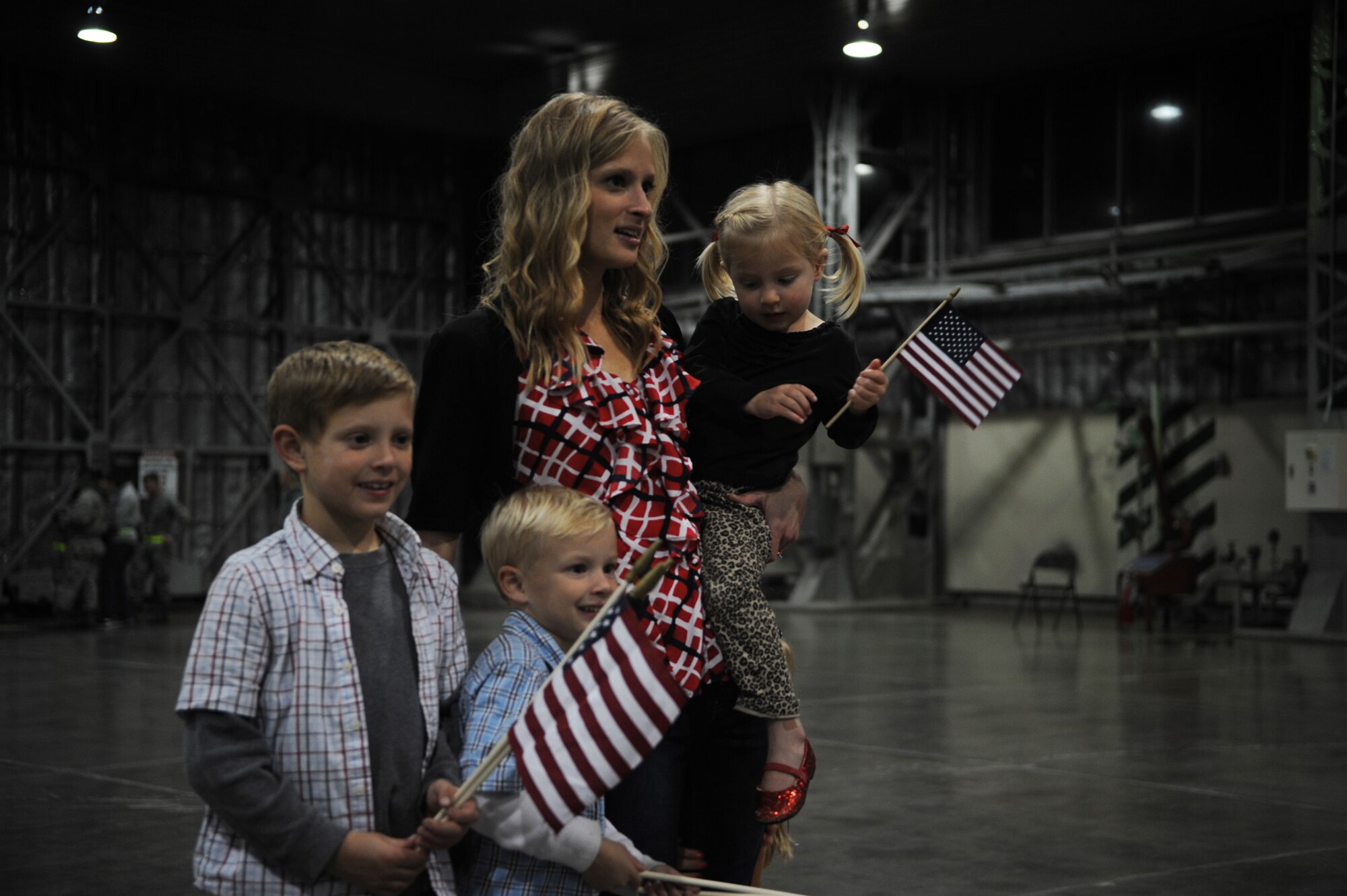 Courtney Dickerson Page and her children await the return of U.S. Air Force Capt. Jefferson Page, 13th Fighter Squadron pilot, from deployment during a homecoming ceremony at Misawa Air Base, Japan, Oct. 14, 2014. The 13 FS was deployed on a six-month tour in support of overseas operations in the Middle East. Page is one of more than 100 Misawa Airmen who recently returned from a deployment to the Middle East where they delivered decisive airpower for U.S. Air Forces Central Command operations, coalition nations and the United States.  (U.S. Air Force photo by Airman Jordyn Rucker/Released)