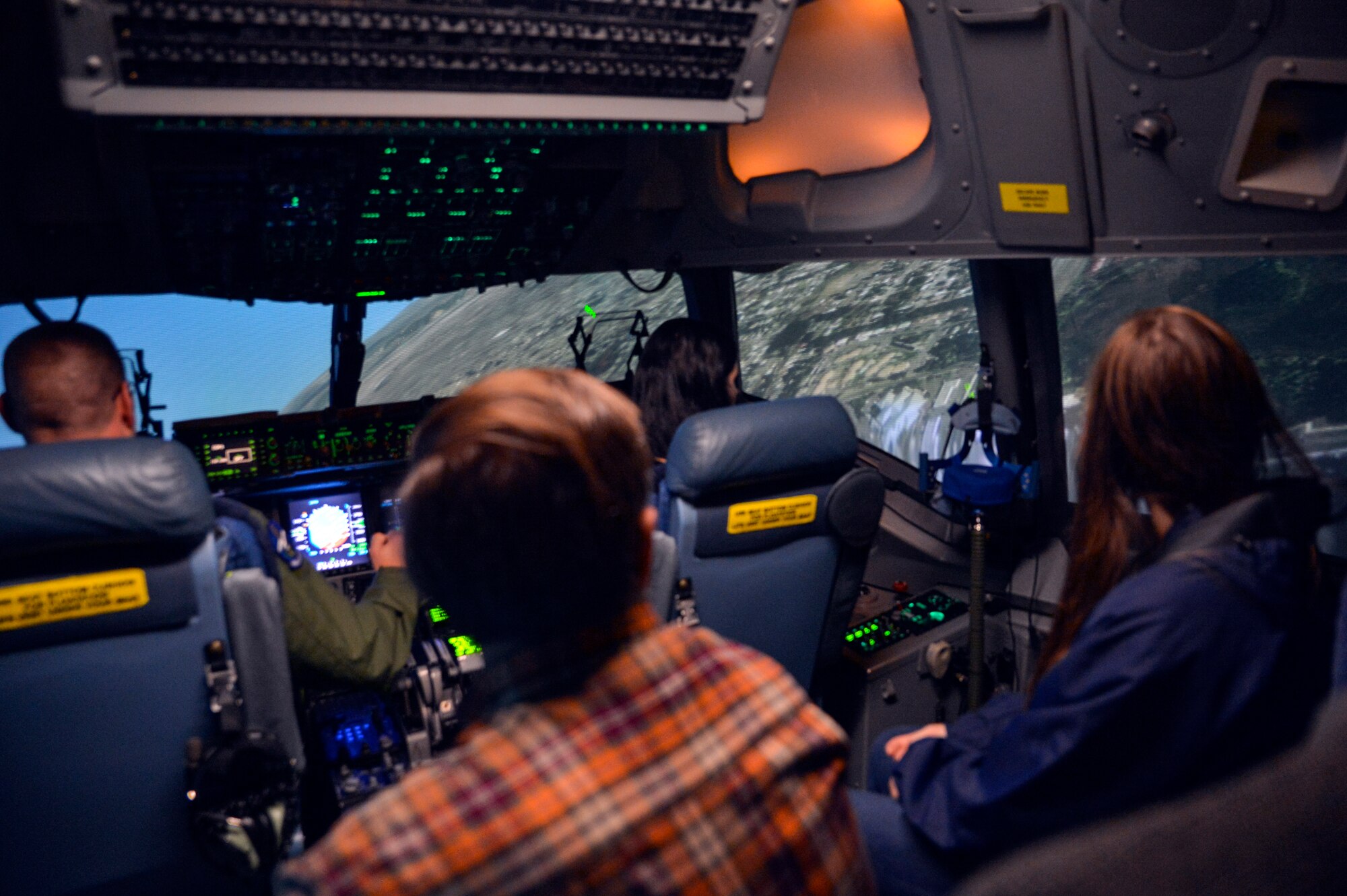 Capt. Jimmy Moxley (left), 7th Airlift Squadron pilot, banks to the right in the C-17 Globemaster III simulator with students from the Aviation Explorer Post 1735 October 25, 2014, during their tour at Joint Base Lewis-McChord, Wash. Each student embraced the opportunity to “fly” the C-17 in the simulator and a few students took part in a simulated in-flight refueling operation. (U.S. Air Force photo/Airman 1st Class Keoni Chavarria)
