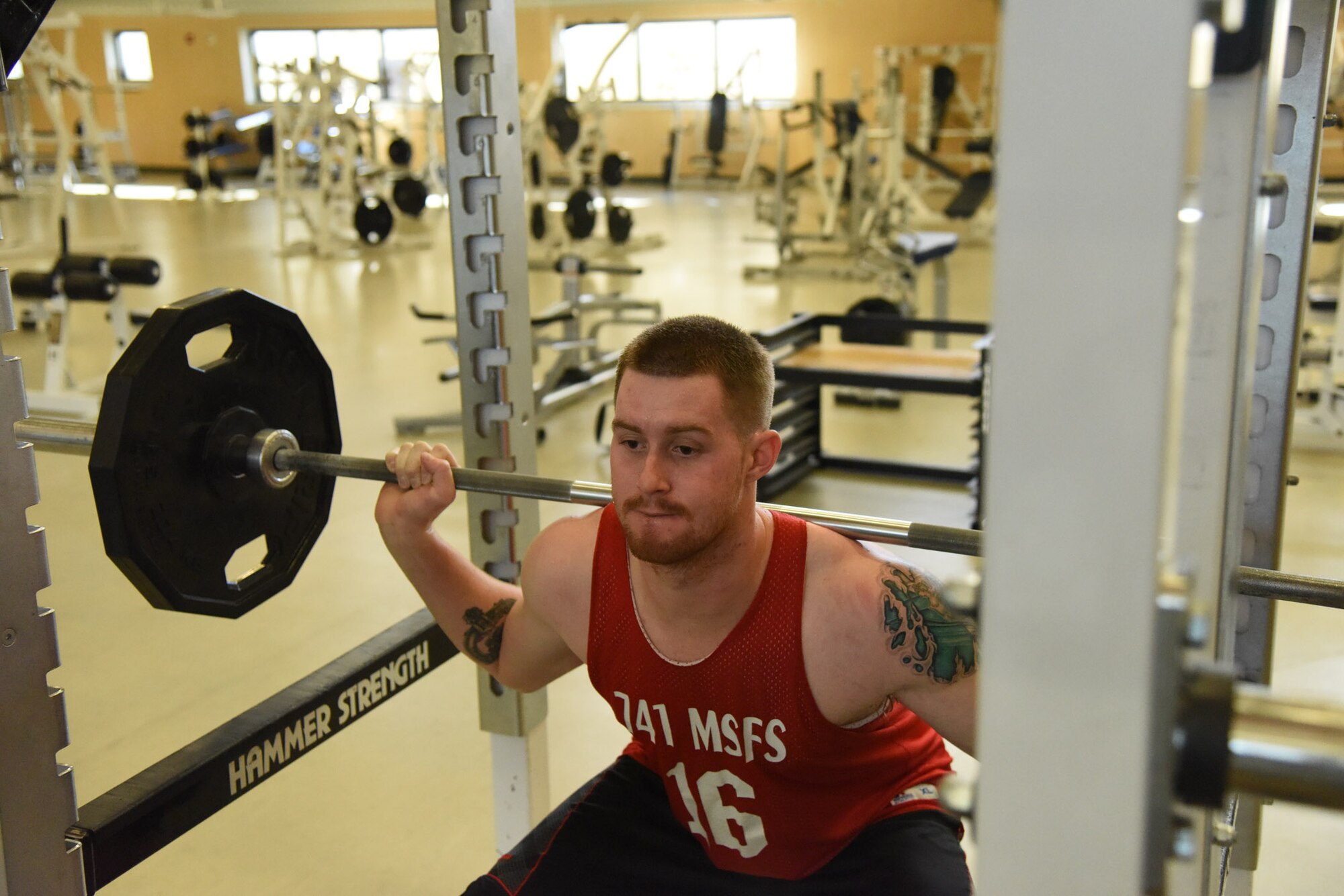 Senior Airman John Robertson, 741st Missile Security Forces Squadron convoy response force leader, performs squats Oct. 17 at the Malmstrom Air Force Base fitness center. Ever since Robertson found out he was selected to try out for the Air Force men’s basketball team, he has been working hard to get in top physical shape to prepare himself. (U.S. Air Force photo/Airman 1st Class Joshua Smoot)