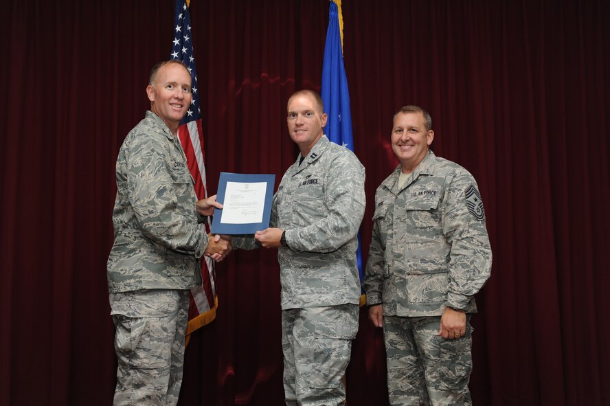 Capt. James Morrison, 33rd Maintenance Squadron, is presented the Gen. Lew Allen, Jr. Trophy, officer category award from Col. Todd Canterbury, 33rd FW commander, and Chief Master Sgt. Scott Berge, 33rd FW command chief, on Eglin Air Force Base, Fla., Oct 17, 2014. Morrison acted as the 58th Aircraft Maintenance Unit officer in charge during this quarter and is now the maintenance operations officer for the 33rd Maintenance Squadron. (U.S. Air Force photo/Staff Sgt. Marleah Robertson)