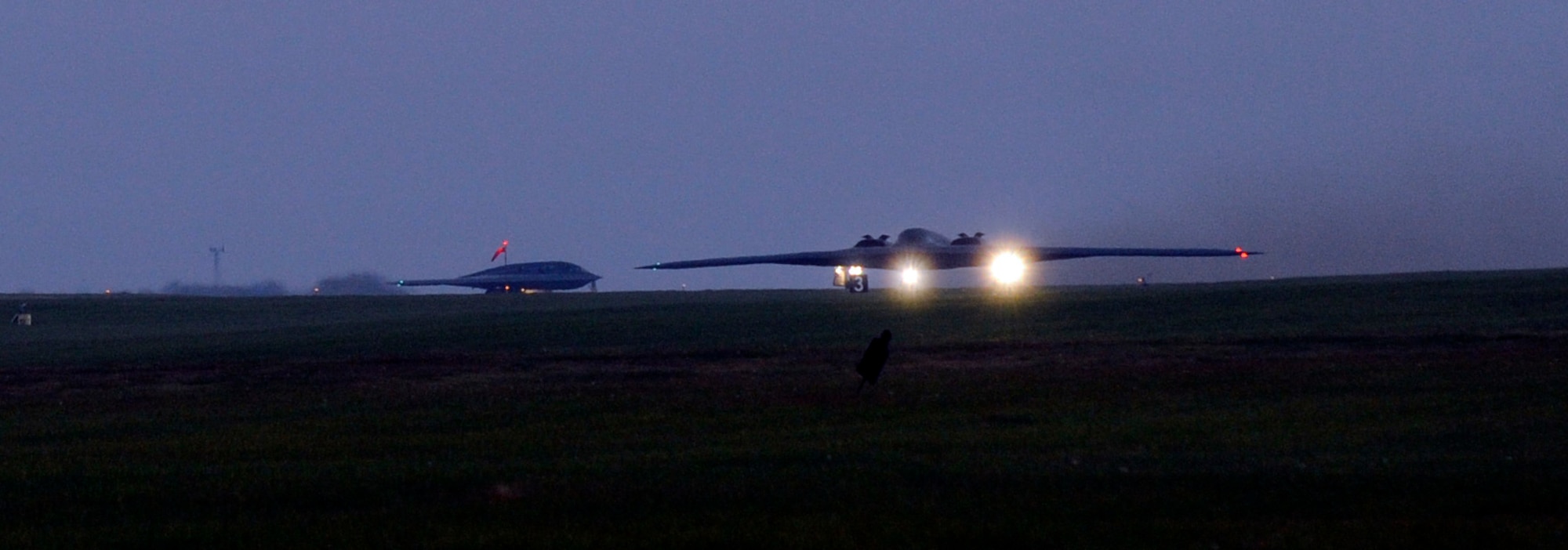 Two B-2 Spirit bombers taxi from Whiteman Air Force Base, Mo., Oct. 26, 2014, in support of Global Thunder 15. Global Thunder is a field training and battle staff exercise designed to exercise all U.S. Strategic Command mission areas with primary emphasis on nuclear command, control and communications.. The B-2 has a crew of two pilots, a pilot in the left seat and mission commander in the right. The B-2 brings massive firepower to bear, in a short time, anywhere on the globe through previously impenetrable defenses. (U.S. Air Force photo by Staff Sgt. Alexandra M. Boutte/Released)