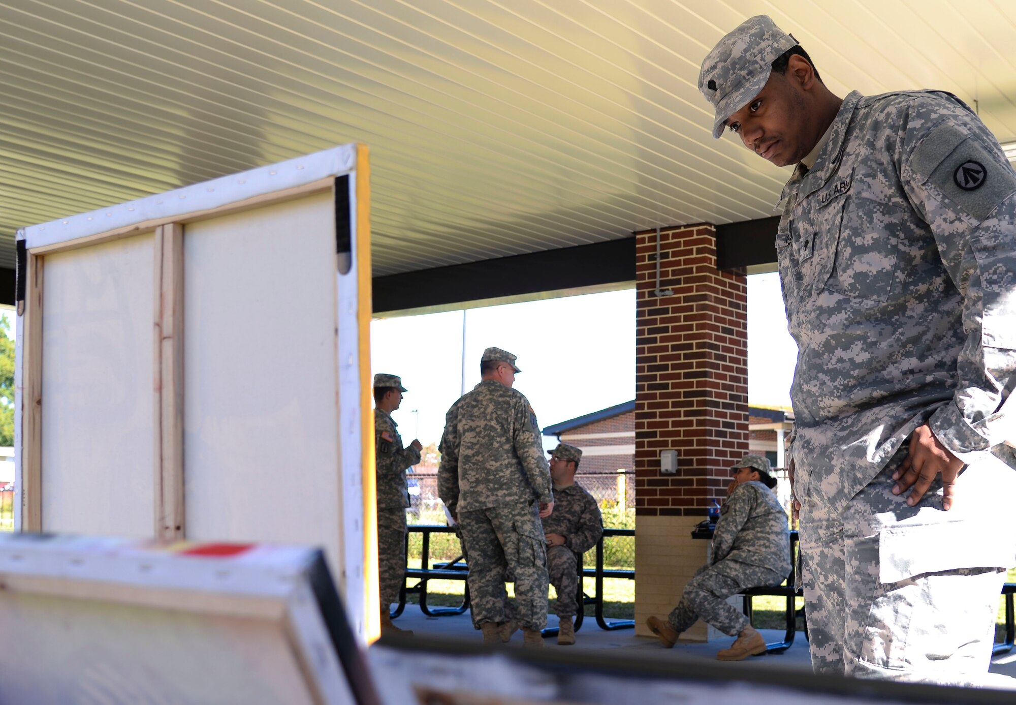 U.S. Army Spc. John Candy, Warrior Transition Unit patient, looks at artwork after the Warrior Care Month opening ceremony at Fort Eustis, Va., Oct. 27, 2014. During WCM, wounded warriors will engage in transition workshops, resiliency classes, morale events and more. (U.S. Air Force photo by Senior Airman Austin Harvill/Released)