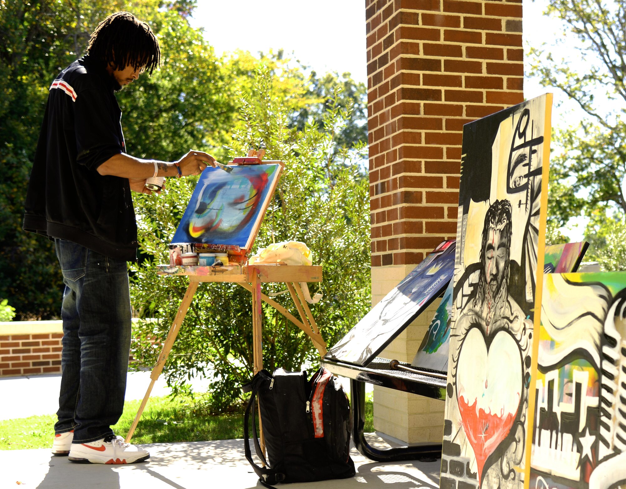 Marvin "Eanjae" Underwood, freelance artist, paints for wounded warriors after the Warrior Care Month opening ceremony at Fort Eustis, Va., Oct. 27, 2014. The four areas the Warrior Transition Unit will focus on during this year's WCM are Resiliency, Recovery, Reintergration and Remaining Strong. (U.S. Air Force photo by Senior Airman Austin Harvill/Released)