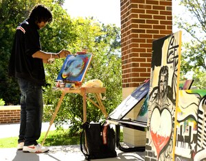 Marvin "Eanjae" Underwood, freelance artist, paints for wounded warriors after the Warrior Care Month opening ceremony at Fort Eustis, Va., Oct. 27, 2014. The four areas the Warrior Transition Unit will focus on during this year's WCM are Resiliency, Recovery, Reintergration and Remaining Strong. (U.S. Air Force photo by Senior Airman Austin Harvill/Released)