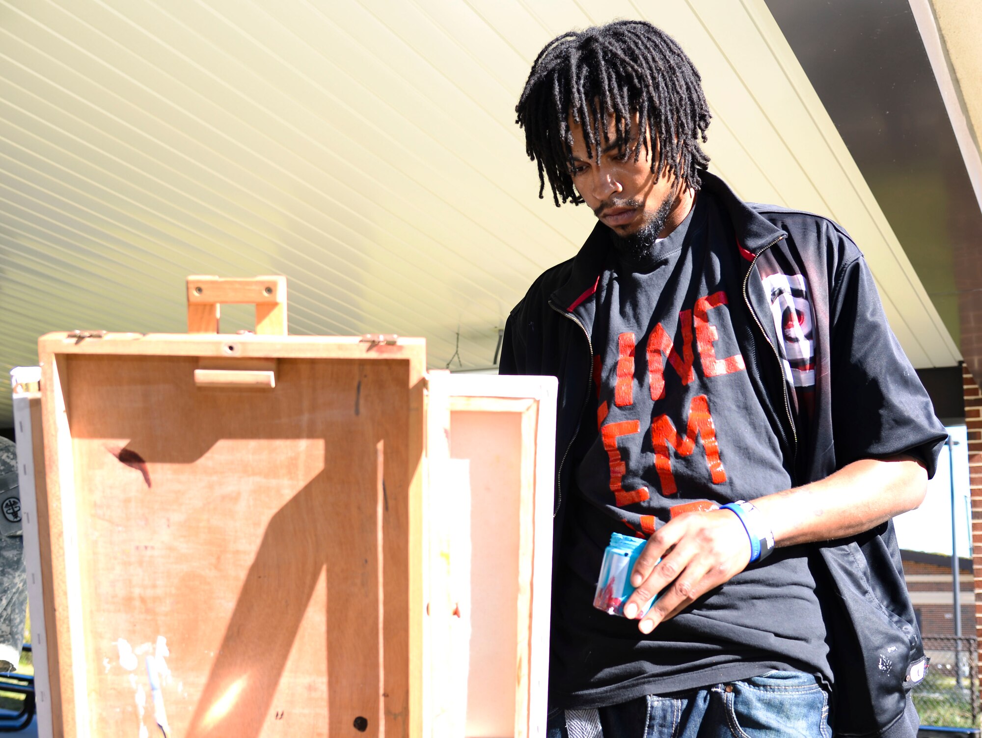 Marvin "Eanjae" Underwood, freelance artist, paints for wounded warriors after the Warrior Care Month opening ceremony at Fort Eustis, Va., Oct. 27, 2014. During the first week of the month, wounded warriors are encouraged to relax with activities like yoga, poetry, therapy dogs, a health fair and more. (U.S. Air Force photo by Senior Airman Austin Harvill/Released)