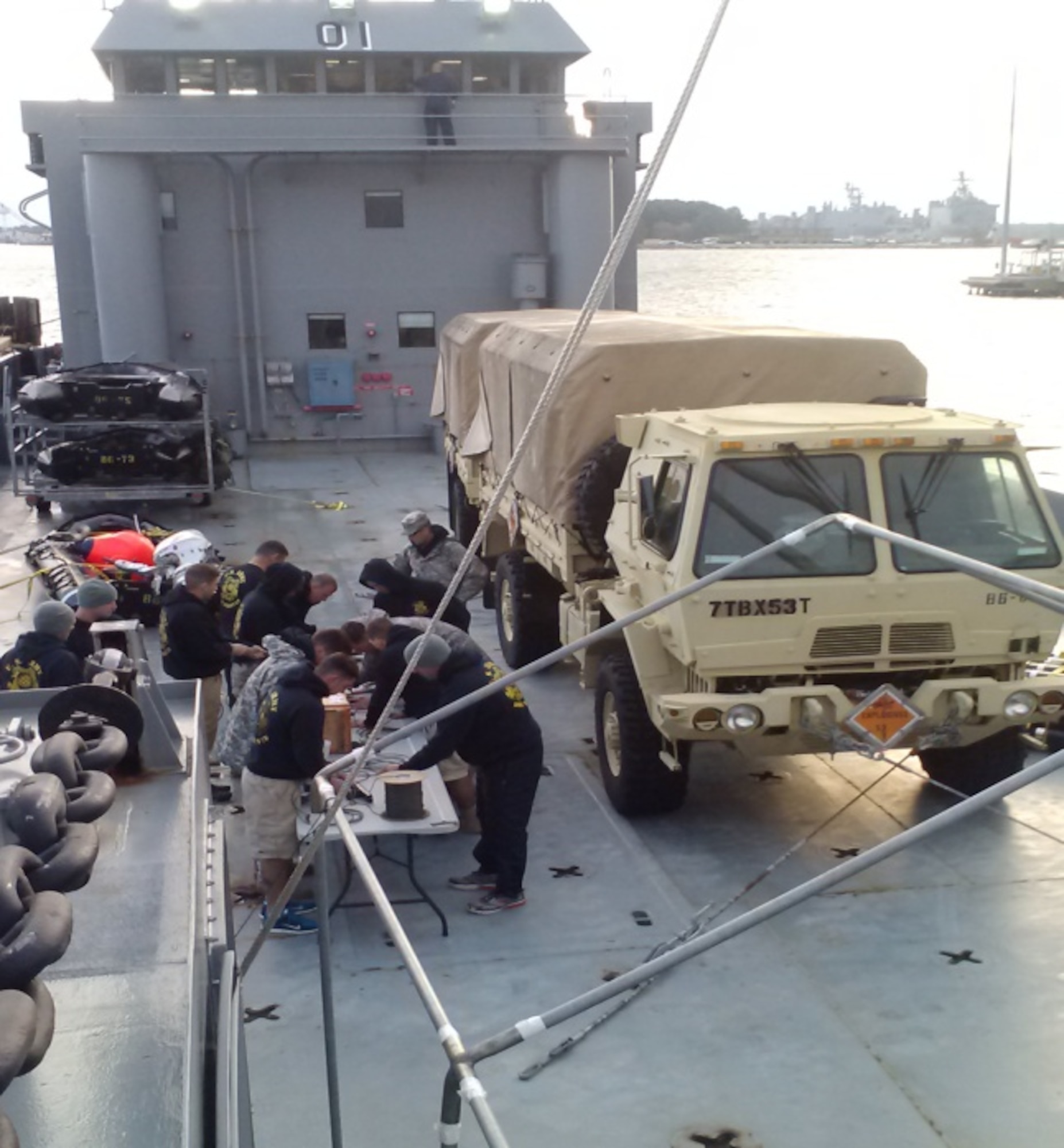 The 86th Engineer Dive Team prepares dummy explosives aboard Landing Craft Utility Runnymede before a training exercise near Fort Eustis, Va., Oct. 23, 2014. The 97th Transportation Company (Heavy Boat) commands seven LCUs, which can be used for a variety of training and real-world missions. (Courtesy photo)