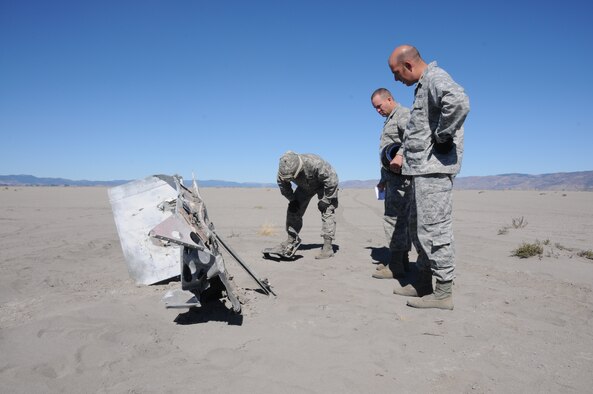 From Right: Maj. Lucas Ritter the casualty assistance officer, Maj. Ryan Bartholomew, the base historian and Staff Sgt. Brandon Stroh of security forces investigate newly exposed wreckage from WWII aircraft on the dry lakebed of Goose Lake, Oct. 3, 2014. Current drought conditions have drawn the water level well below parts of the lakebed for the first time. The aircraft flights originated at Kingsley Field for training and unfortunately never returned to the base.  (U.S. Air National Guard photo by Tech. Sgt. Jefferson Thompson)