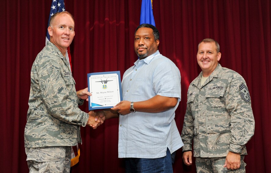 Wayne Wilson, 33rd Fighter Wing budget analyst, is presented the 33rd Fighter Wing civilian of the quarter category III award from Col. Todd Canterbury, 33rd FW commander, and Chief Master Sgt. Scott Berge, 33rd FW command chief, on Eglin Air Force Base, Fla., Oct 17, 2014. Wilson managed the limitation metric by balancing a $12.4 million budget across 10 Congress, Department of Defense and Air Force mandates, allowing the 33rd FW to fall in line with strategic goals. (U.S. Air Force photo/Staff Sgt. Marleah Robertson)
