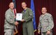 Lt. Col. Brad Turner, 33rd Fighter Wing chief of safety, accepts the 33rd FW company grade officer of the quarter award on behalf of Capt. Daniel Haley, 33rd FW flight safety officer, from Col. Todd Canterbury, 33rd FW commander, and Chief Master Sgt. Scott Berge, 33rd FW command chief, on Eglin Air Force Base, Fla., Oct 17, 2014. Haley is recognized for being the lead advisor to the accident and safety investigation boards for the first F-35A Lightning II Class-A mishap. His actions were lauded by Gen. Robin Rand, Air Education and Training Command commander. (U.S. Air Force photo/Staff Sgt. Marleah Robertson)