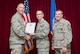 Staff Sgt. Jake Cline, 33rd Maintenance Group crew chief, is presented the 33rd Fighter Wing non-commissioned officer of the quarter award from Col. Todd Canterbury, 33rd FW commander, and Chief Master Sgt. Scott Berge, 33rd FW command chief, on Eglin Air Force Base, Fla., Oct 17, 2014. Cline led an Autonomic Logistics Information System working group designed to draft the first technical manual aimed at filling the gap between Air Force Instructions and Lockheed Martin sustainment operating instructions. (U.S. Air Force photo/Staff Sgt. Marleah Robertson)