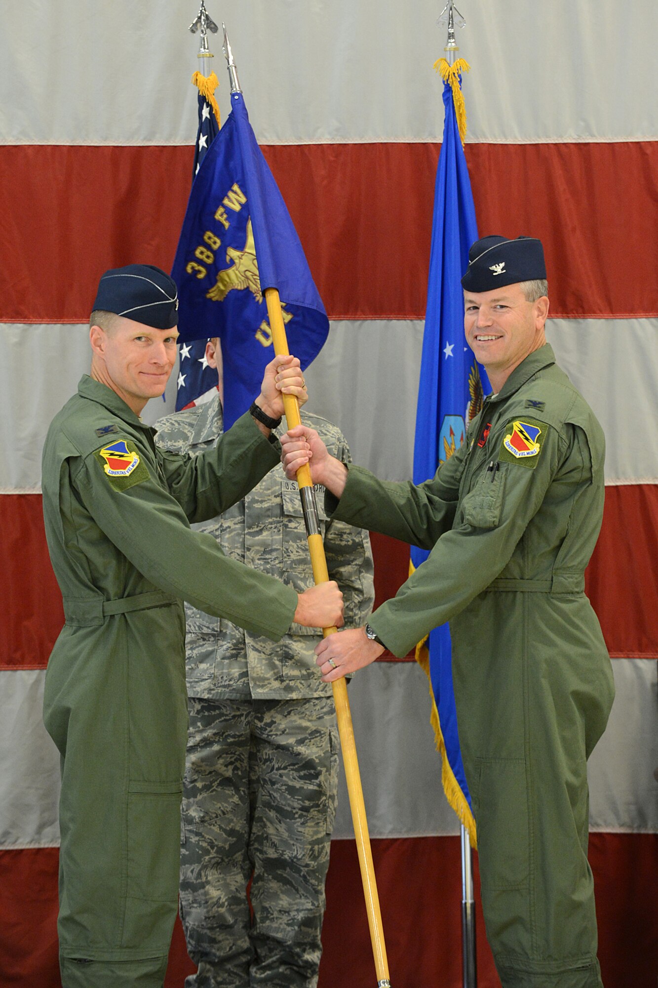 Col. Lance Landrum, 388th Fighter Wing commander, passes the guidon to incoming Utah Test and Training Range Commander Col. Paul Delmonte during a change of command ceremony at Hill Air Force Base Oct. 27.  