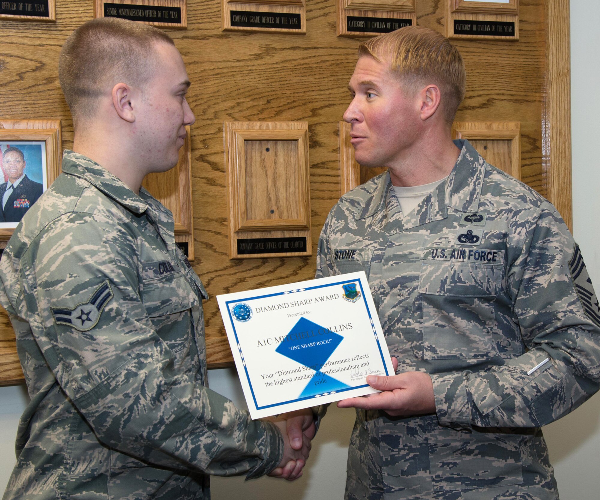 Chief Master Sgt. Brian Stone, Air Force Materiel Command first sergeant functional, presents Airman 1st Class Mitchell Collins, 66th Comptroller Squadron customer service technician, with the Diamond Sharp Award in the Brown Building Oct. 27. The first sergeants selected Collins as the recipient of the award for performance reflecting the highest standard of professionalism and pride. (U.S. Air Force photo by Mark Herlihy)