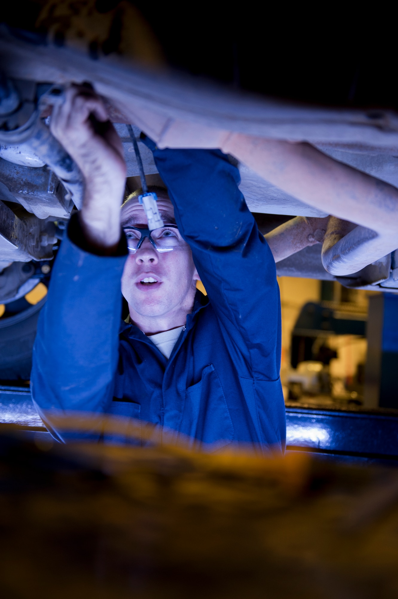 Airman 1st Class Gray Bishop, 5th Logistics Readiness Squadron vehicle maintenance apprentice, changes the oxygen sensors under a vehicle on Minot Air Force Base, N.D., Oct. 17, 2014. Airmen from the 5th LRS vehicle maintenance flight repair and maintain various types of vehicles to ensure Minot AFB stays mobile. (U.S. Air Force photo/Senior Airman Brittany Y. Bateman)