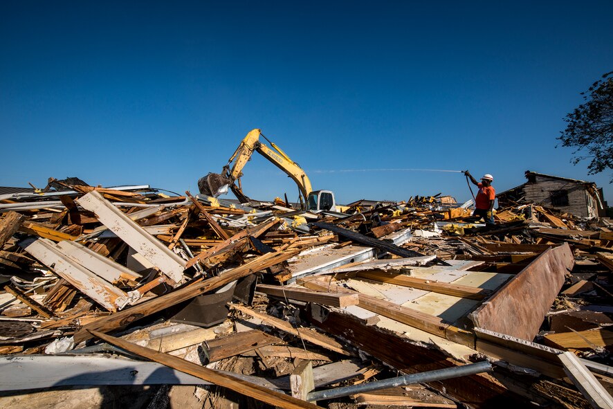 Construction workers hose down and remove pieces of a demolished building Oct. 28, 2014, at Moody Air Force Base, Ga. The site housed buildings belonging to the 23d Civil Engineer Squadron, who will move back in when a new building is constructed in 2016. (U.S. Air Force photo by Airman 1st Class Ryan Callaghan/Released)